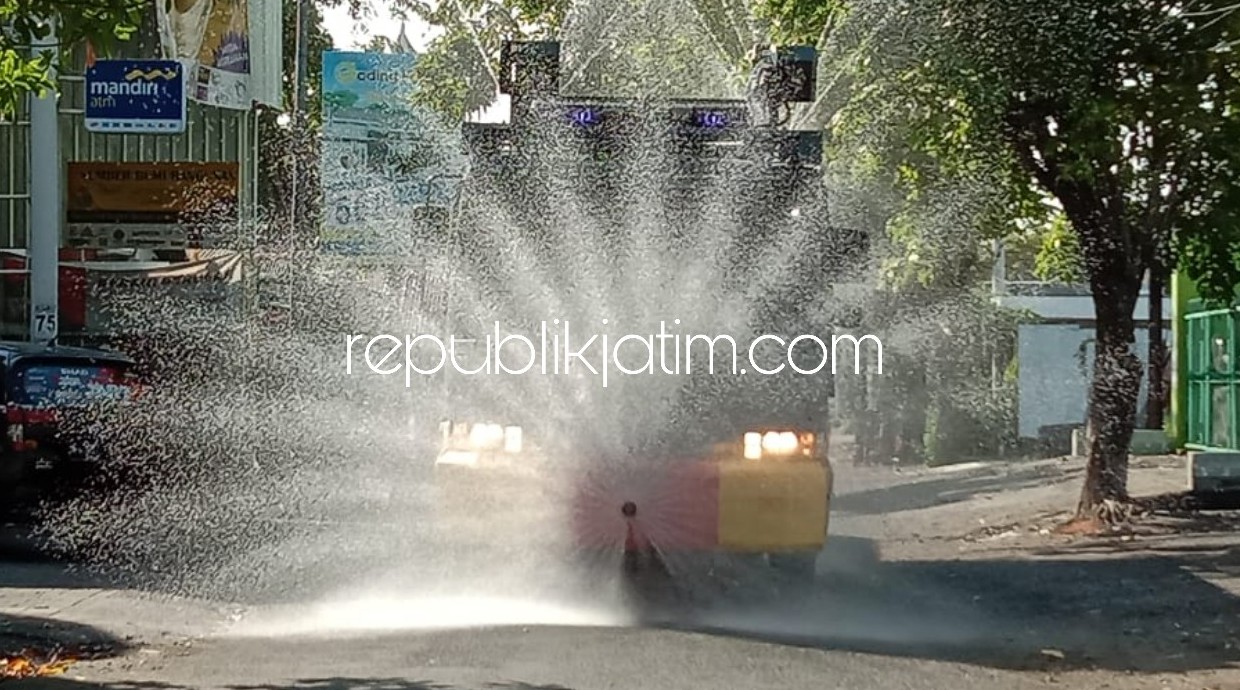 SEMPROT DISINFEKTAN - Petugas Polresta Sidoarjo kembali melaksanakan penyemprotan disinfektan ke sejumlah ruas jalan protokol usai apel pembagian 300 masker di Polresta Sidoarjo, Minggu (10/05/2020).