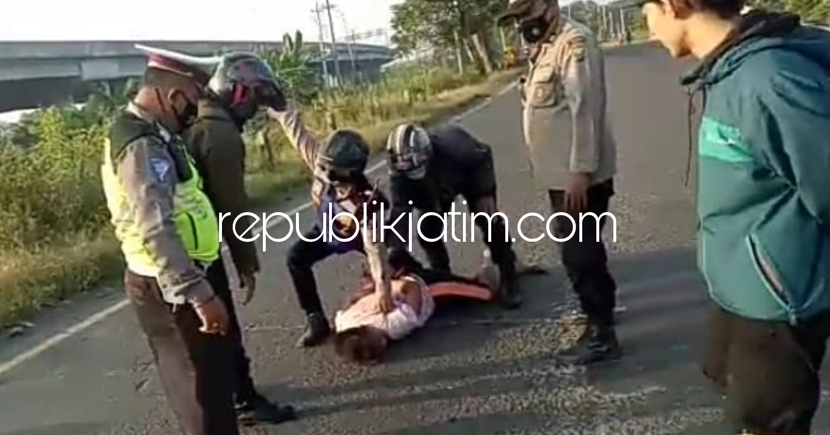 NGAMUK - Seorang pemuda ditenangkan petugas kepolisian saat mengamuk di JL Arteri Gempol Sampurno, Kelurahan/Kecamatan Porong, Sidoarjo, Kamis (13/05/2021).