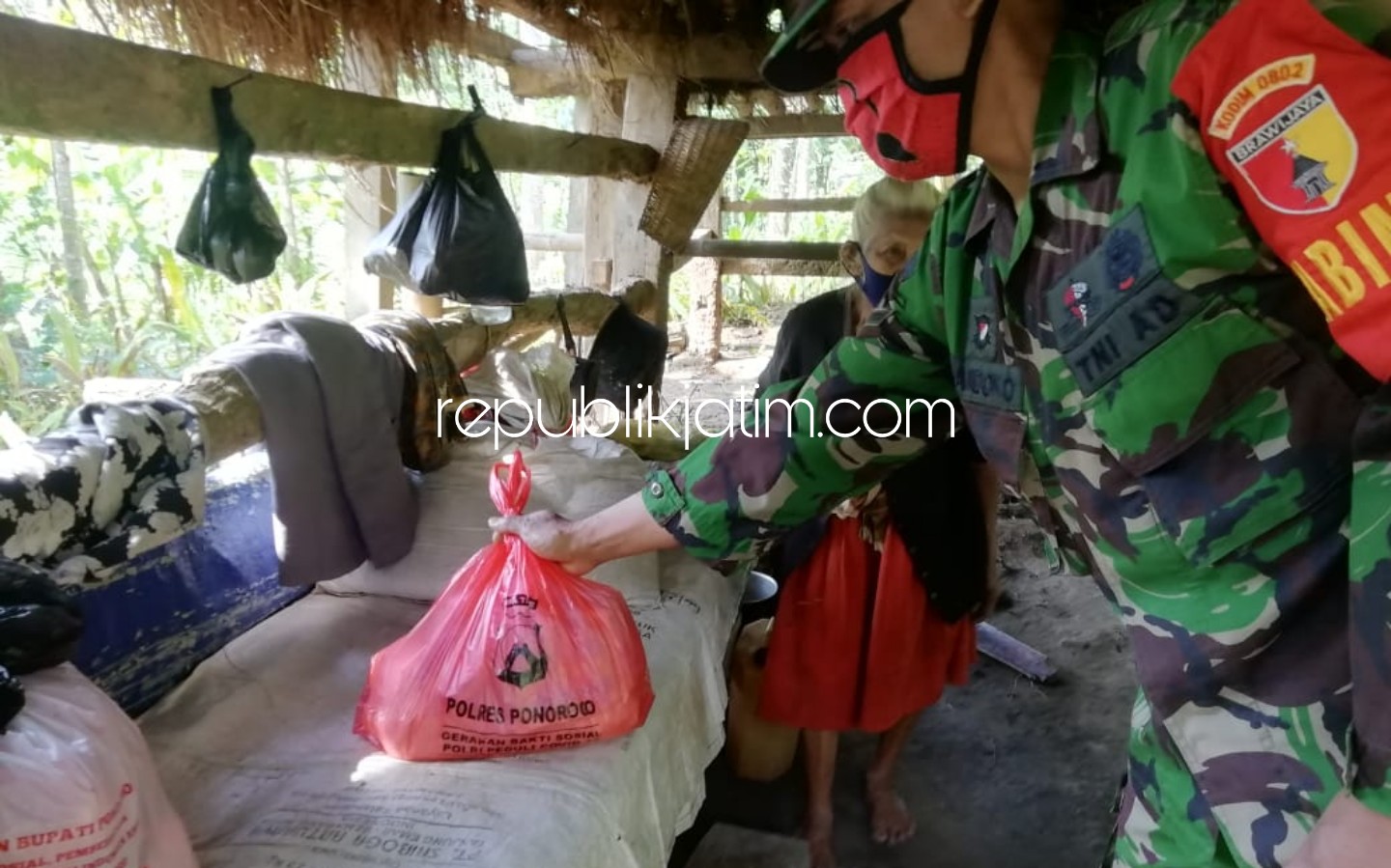 BANTUAN - Petugas saat menyerakan bantuan kepada Mbah Tukinem warga Dusun Krajan, Desa Baosan Lor, Kecamatan Ngrayun, Ponorogo yang hidup sebatangkara di kandang sapi milik tetangga, Jumat (15/05/2020).