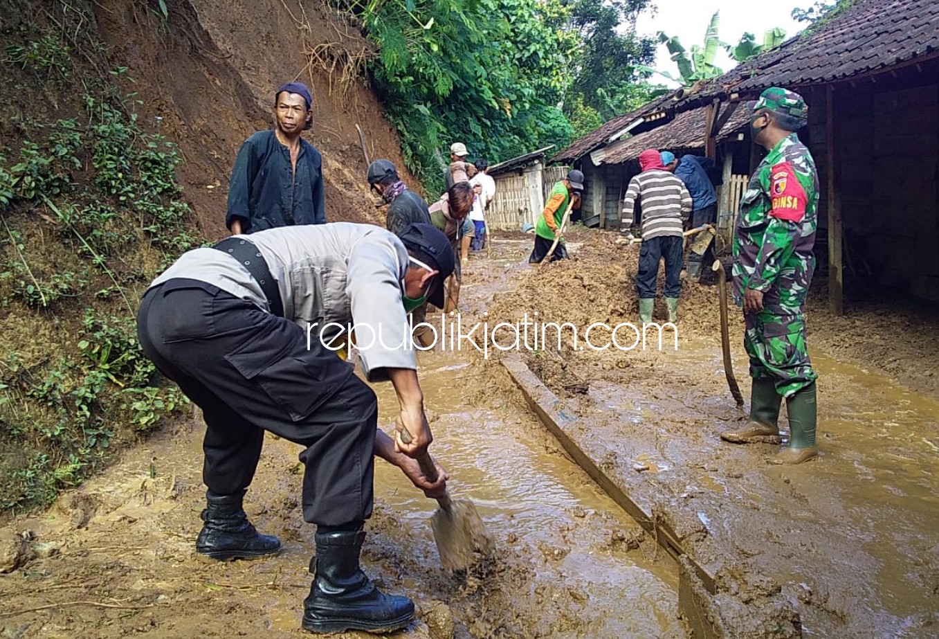 LONGSOR - Petugas Polsek dan Koramil Pudak bersama warga kerja bakti bersihkan longsoran dan menyerahkan bantuan kepada korban longsor, Darmawan warga Dusun Sunten, Desa Banjarejo, Kecamatan Pudak, Ponorogo Minggu (17/05/2020).