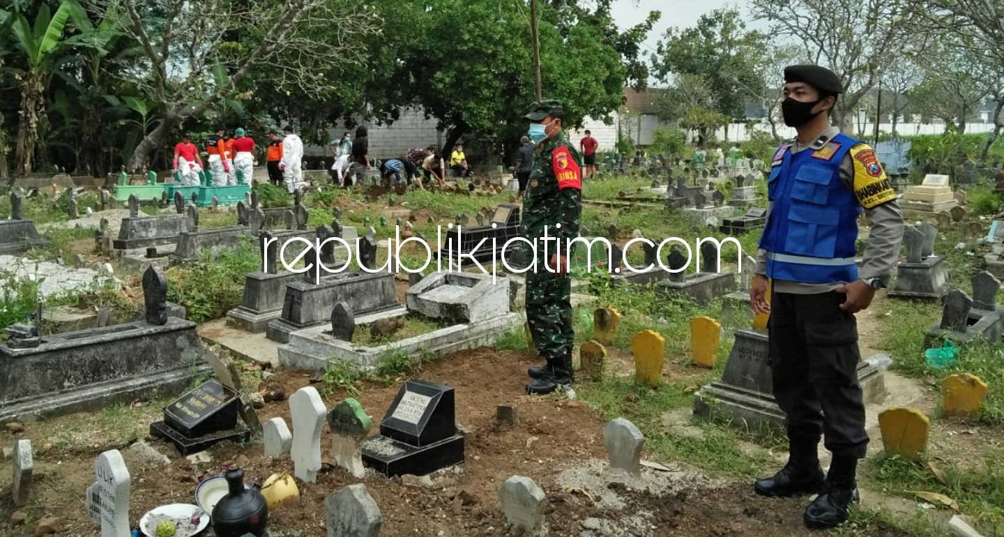 PEMAKAMAN - Sejumlah anggota Polsek Ponorogo saat mengamankan pemakaman jenazah pasien Covid-19 di Kecamatan Ponorogo, Selasa (18/05/2021).