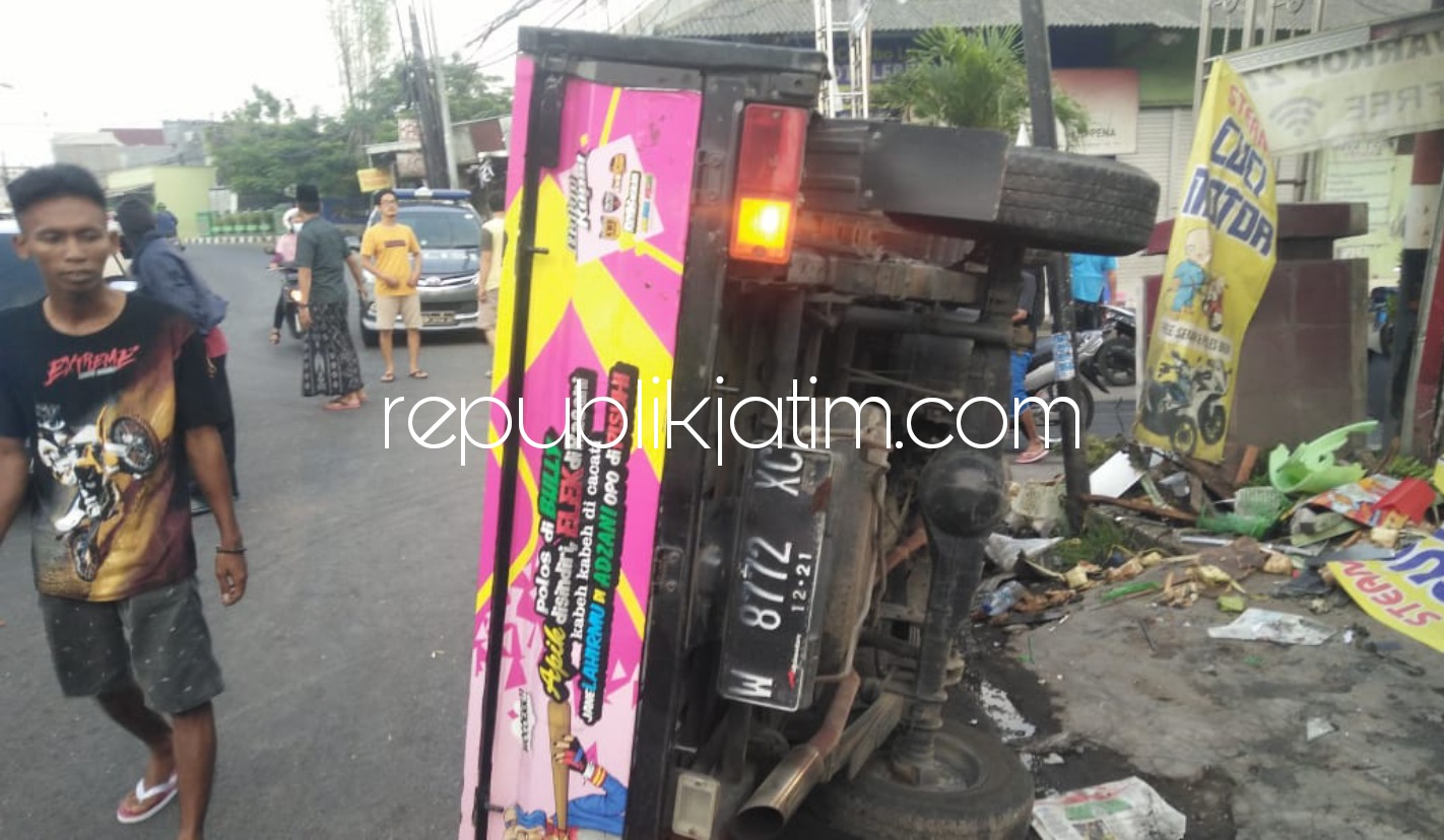 TERGULING - Sebuah pikup Grand Max bernopol W 8772 XC terbalik di JL Raya Desa Pabean, Kecamatan Sedati, Sidoarjo usai menabrak motor dan rombong penjual gorengan, Selasa (18/05/2021). 