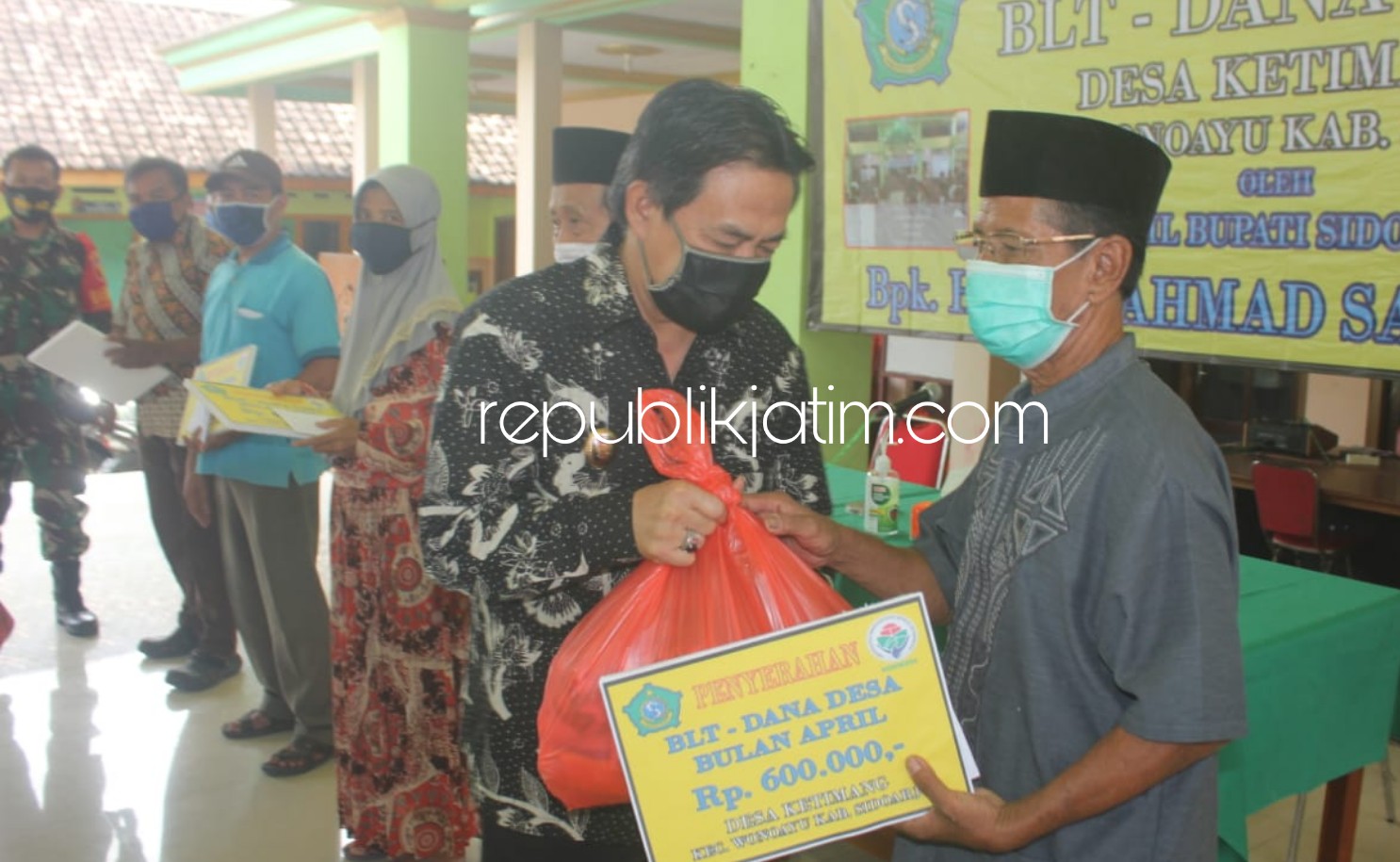 SERAHKAN - Plt Bupati Sidoarjo, Nur Ahmad Syaifuddin menyerahkan Bantuan Langsung Tunai Dana Desa (BLT DD) untuk 99 warga Desa Ketimang, Kecamatan Wonoayu, Sidoarjo, Selasa (19/05/2020).