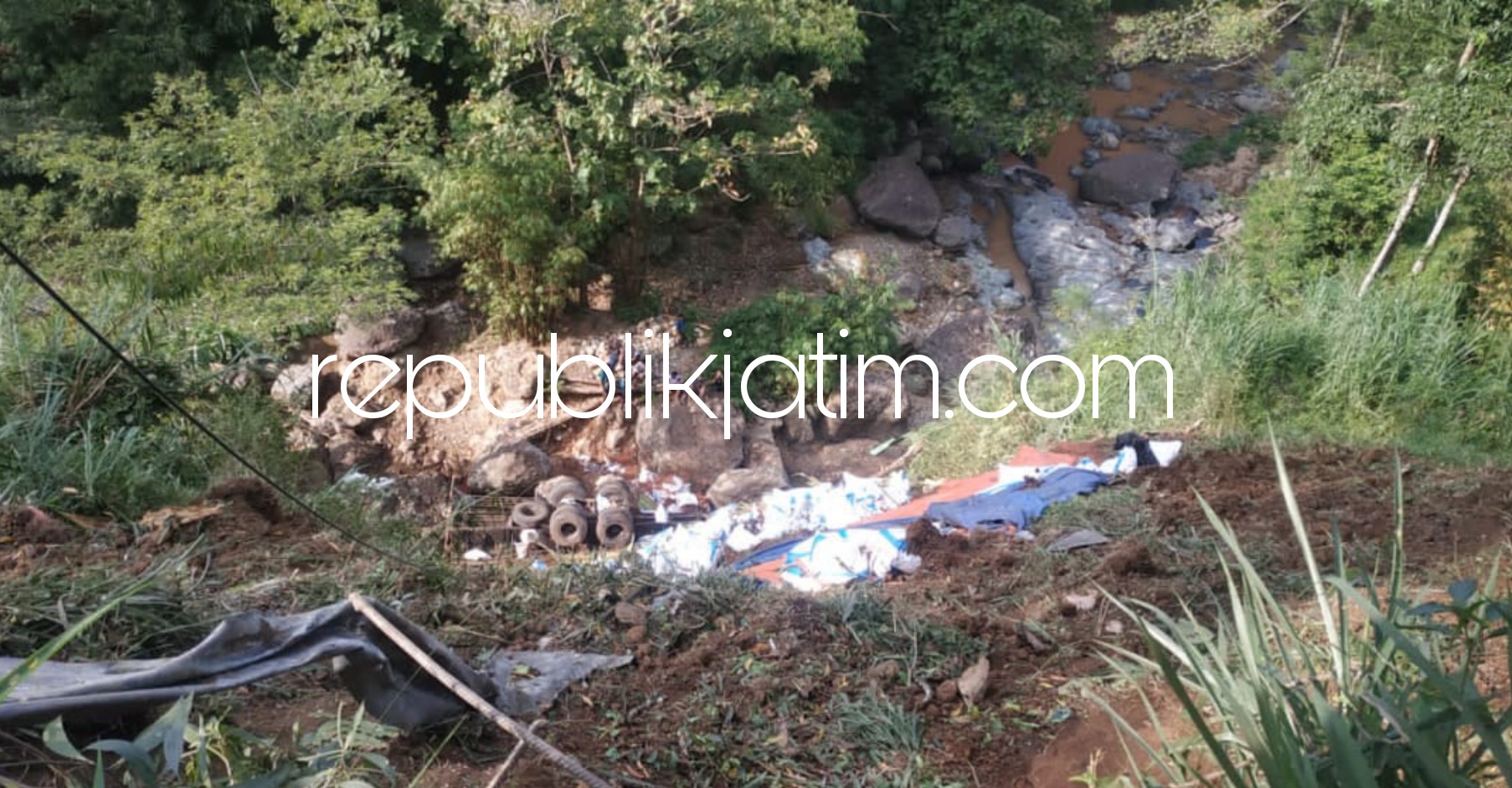 MASUK JURANG - Petugas Unit Laka, Satuan Lantas, Polres Pacitan saat olah TKP kecelakaan truk tronton muatan 35 ton pupuk yang masuk jurang Sungai Girindalu sedalam 50 meter, Rabu (19/05/2021).