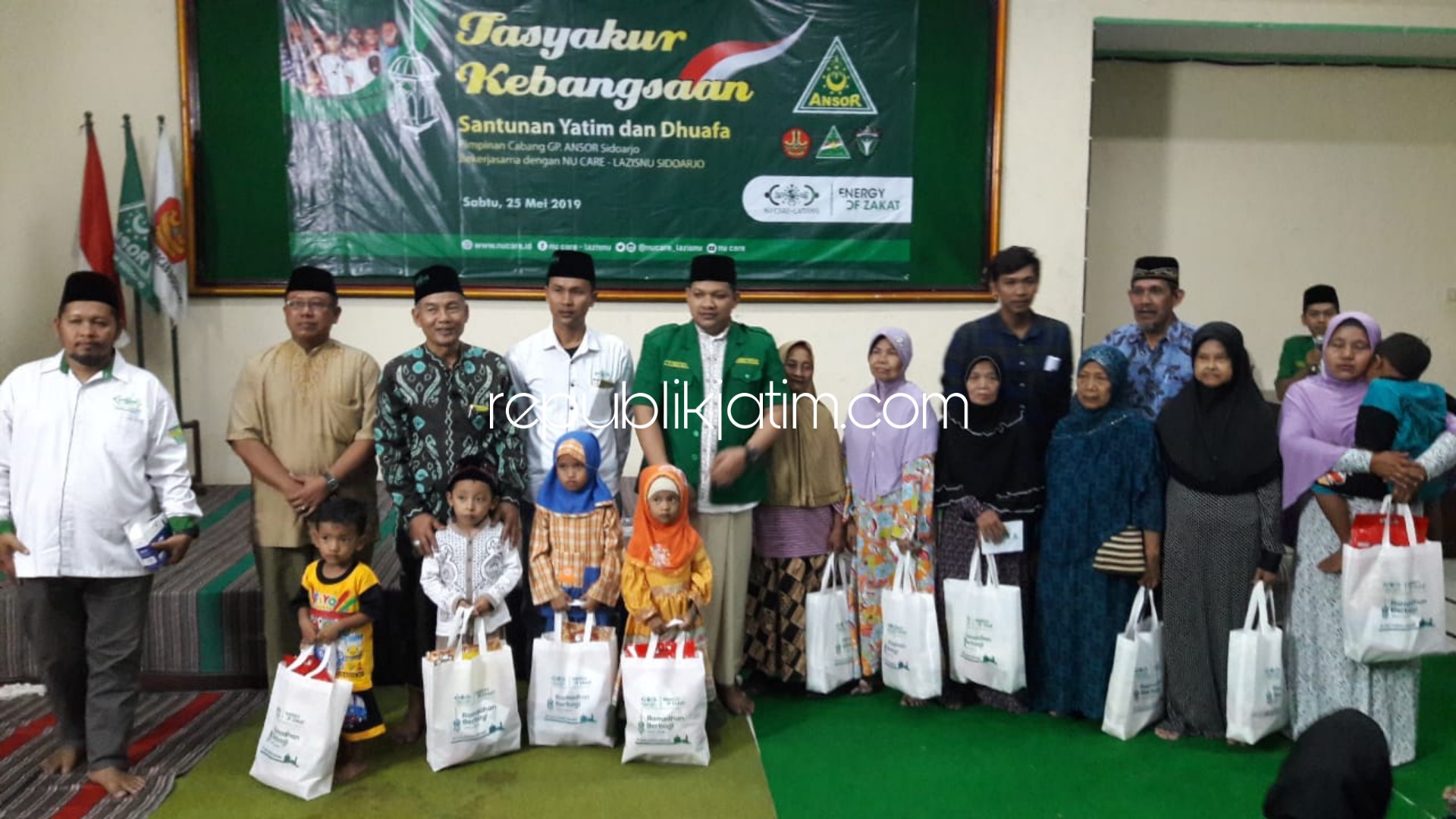SANTUNAN - Ketua PC GP Ansor Sidoarjo, Rizza Ali Faizin didampingi Direktur NU Care - Lazisnu Sidoarjo, Dodi Diyauddin membagikan santunan dan bingkisan kepada 100 yatim piatu dan 50 dhuafa saat Tasyakuran Kebangsaan, Sabtu (25/05/2019) petang.