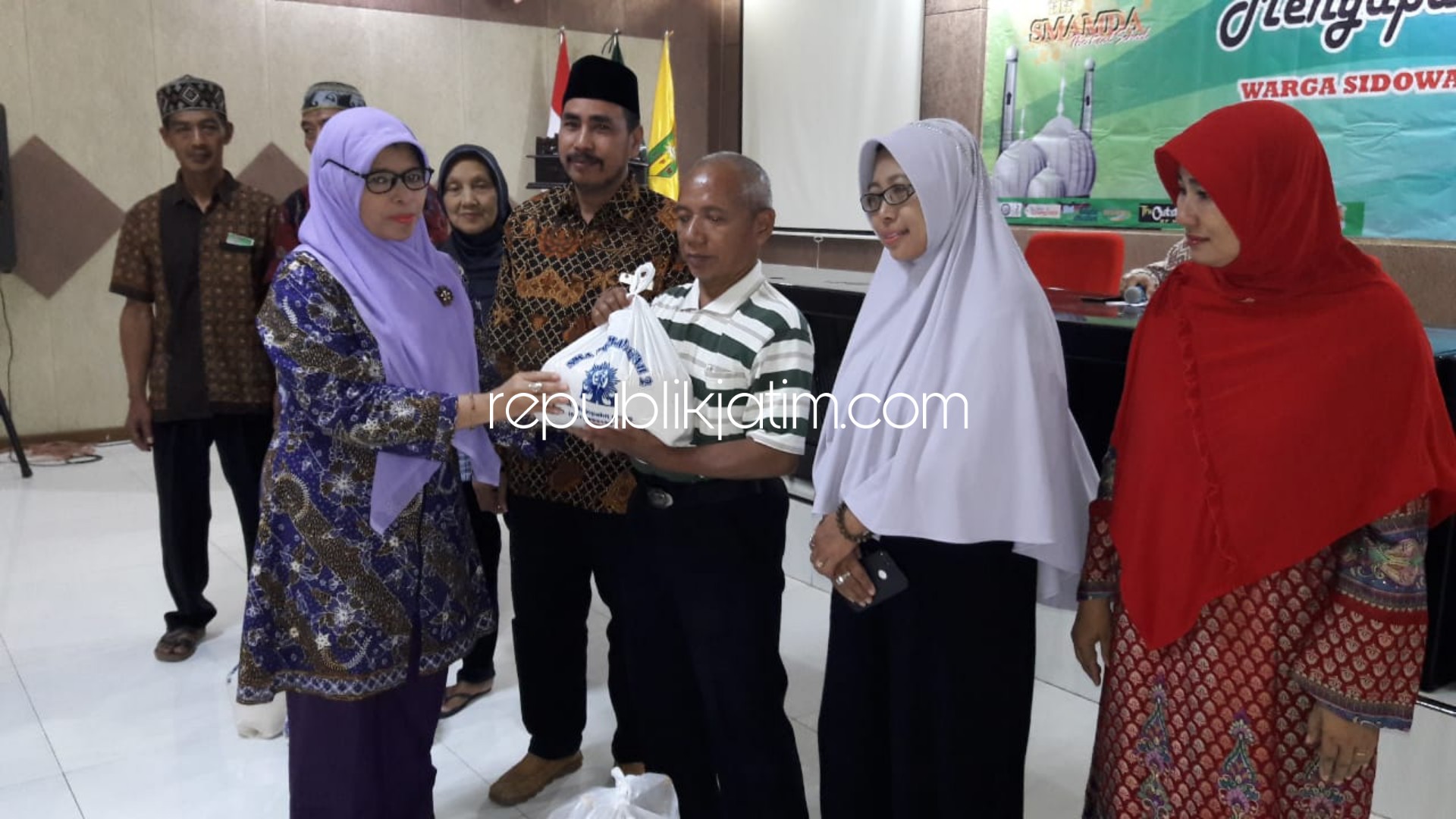 BERBAGI - Kepala Smamda, Wigatiningsih memberikan santukan, paket sembako dan parcel kepada 202 warga Sidowayah, Kecamatan Sidoarjo bagian kegiatan Menyapa dan Berbagi, Rabu (29/05/2019) petang.