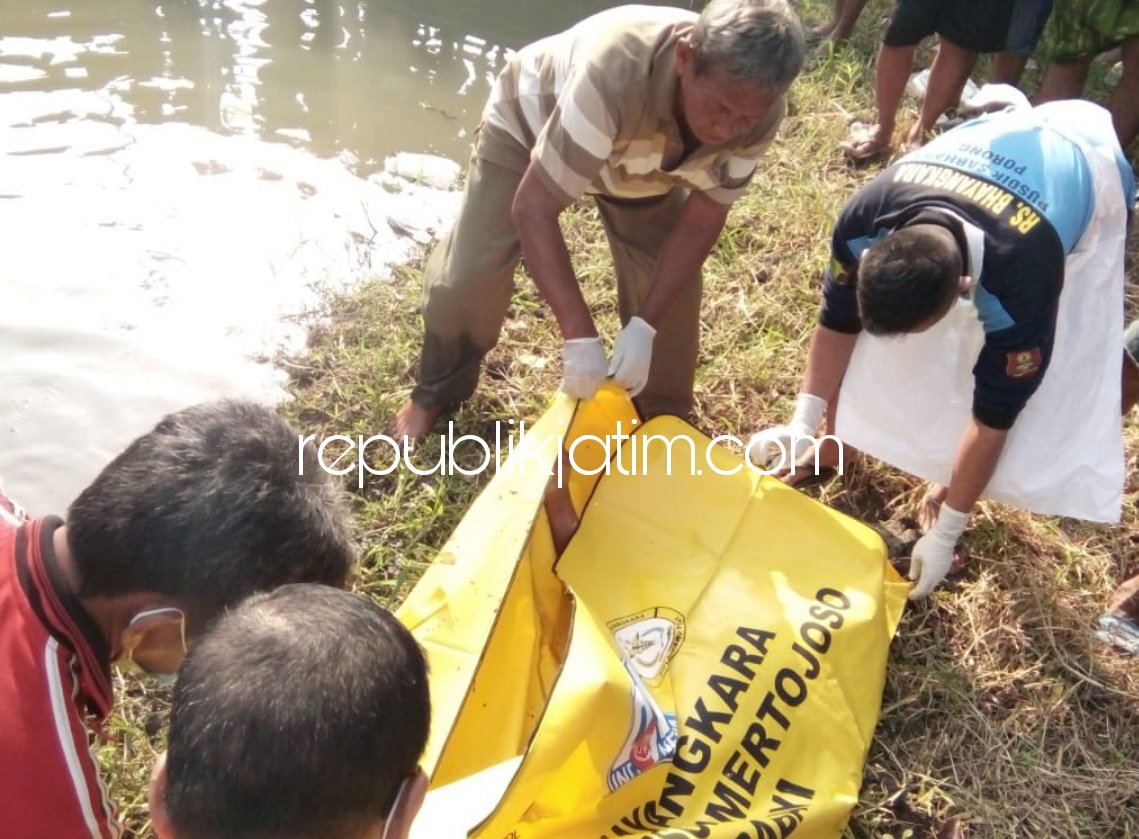EVAKUASI - Sejumlah petugas Polsek Porong dan tim inafis mengevakuasi jenazah Suparman (45) warga Desa Banjarasri, Kecamatan Tanggulangin yang ditemukan tewas mengapung di Sungai Kelurahan/Kecamatan Porong, Sidoarjo, Selasa (08/06/2021).