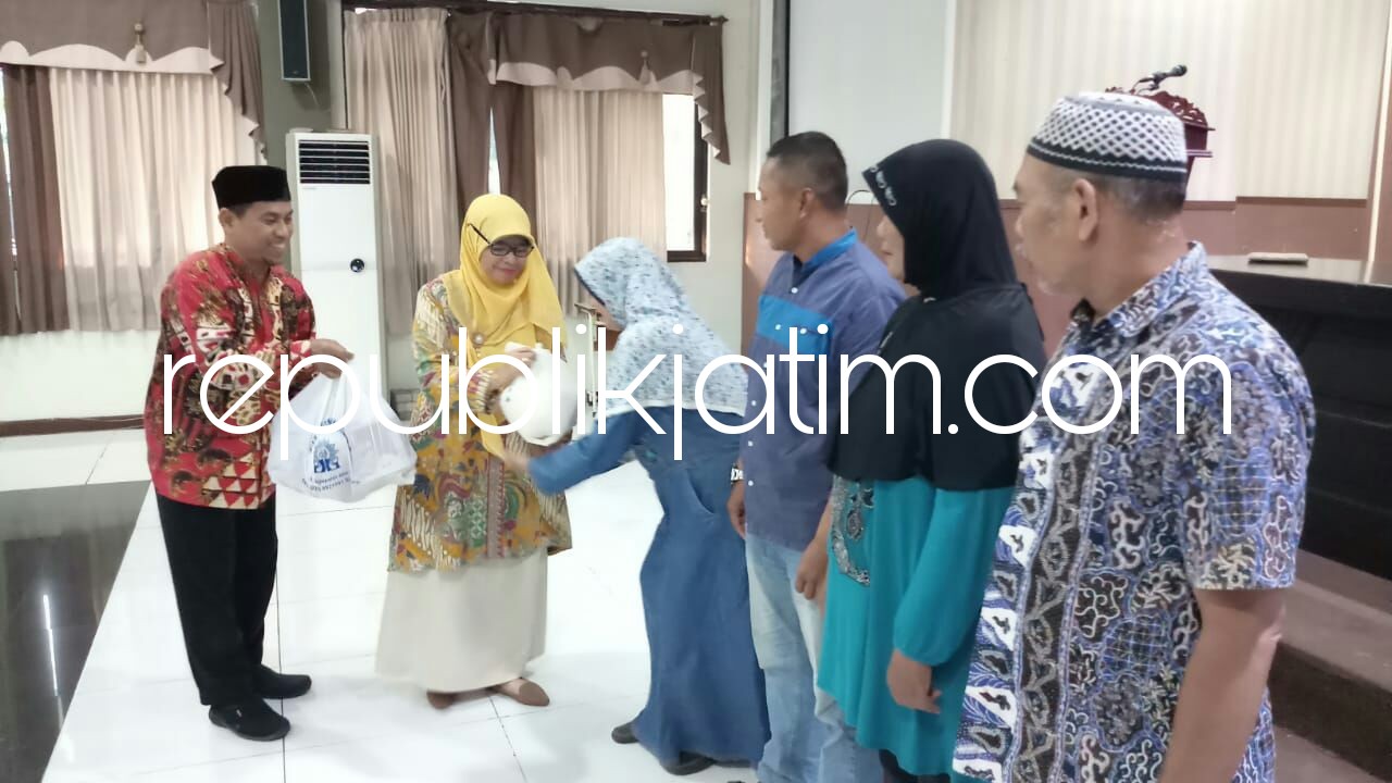 BERBAGI - Kepala Smamda Sidoarjo, Wigatiningsih menyerahkan bingkisan Lebaran kepada sekitar 200 warga sekitar sekolah dalam acara buka bersama, Sabtu (09/06/2018). 