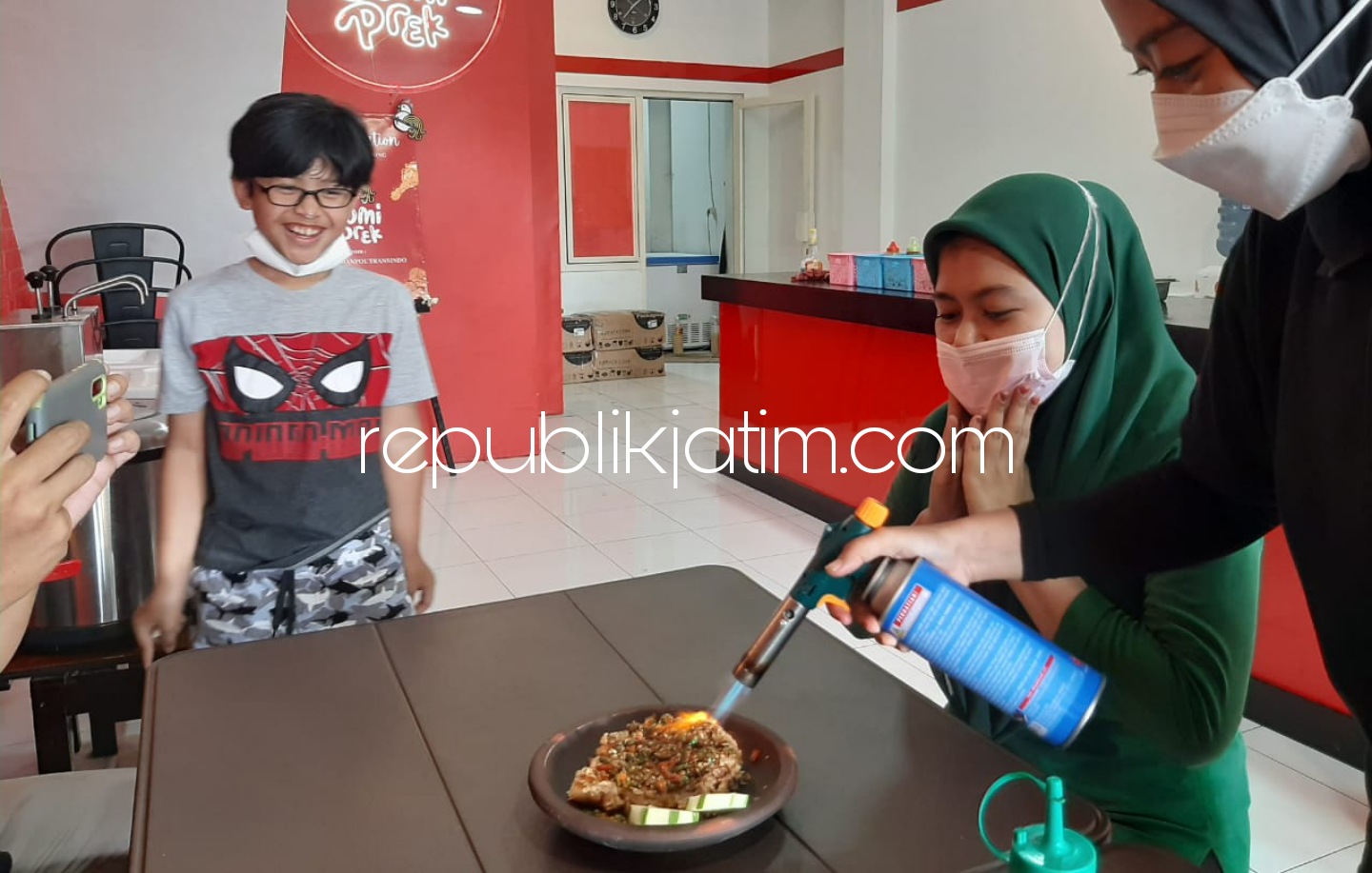 BAKAR - Puguh Budiono owner Resto Ayam Geprek Cobek Bakar saat menyajikan menunya untuk pembeli, Minggu (13/06/2021).