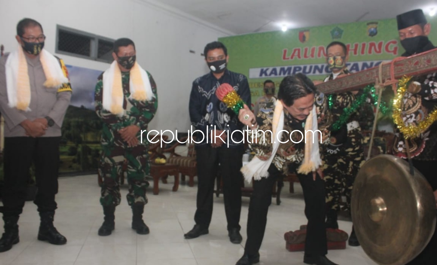 AMPUNG TANGGUH - Ketua Gugus Tugas Covid-19 Sidoarjo, Nur Ahmad Syaifuddin memukul gong tanda peresmian Kampung Tangguh di Desa Gempolsari, Kecamatan Tanggulangin, Sidoarjo, Selasa (23/06/2020) malam.