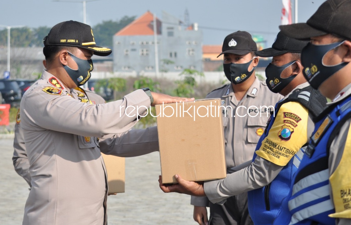 BANTUAN - Wakapolresta Sidoarjo AKBP Deny Agung Andriana menyerahkan paket sembako kepada Bhabinkamtibmas dalam menyambut hari Bhayangkara ke 74, Jumat (26/06/2020). 