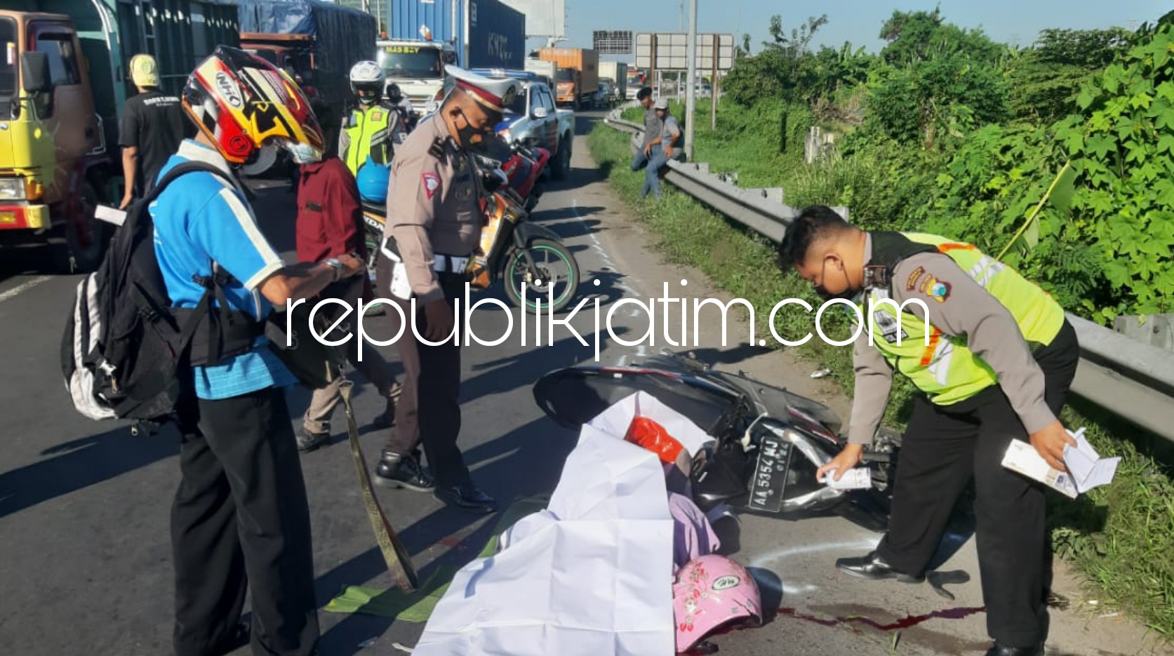 EVAKUASI - Sejumlah petugas Unit Laka, Satuan Lantas, Polresta Sidoarjo mengevakuasi jenazah korban kecelakaan, Defi Winarsih (27) warga Desa Jagakerten, Kecamatan Kenogojayan, Kabupaten Kebumen di JL Raya Surabaya - Mojokerto, Kamis (01/07/2021) sore.
