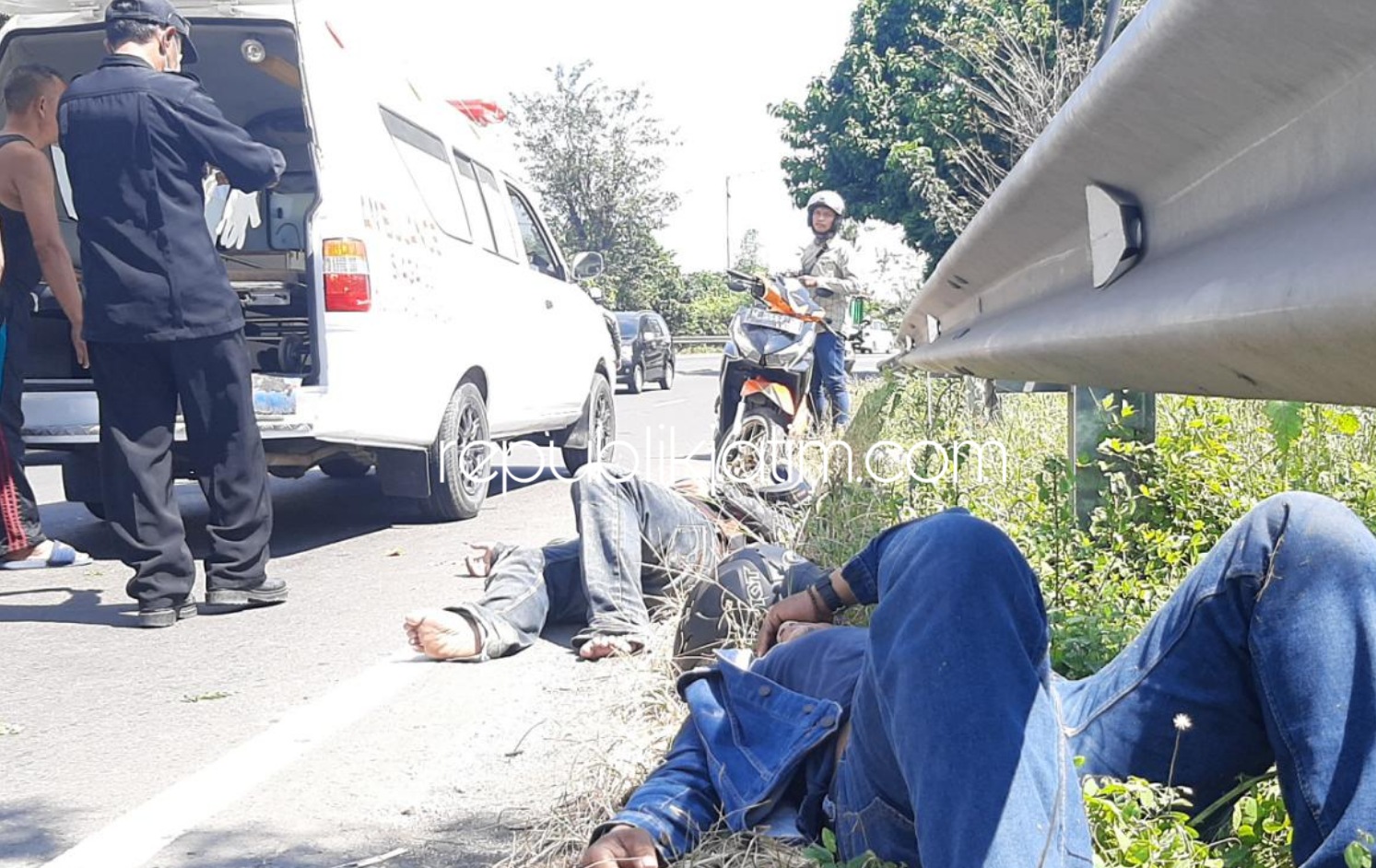 EVAKUASI - Sejumlah petugas dan warga mengevakuasi kedua korban kecelakaan di JL Raya Surabaya - Mojokerto, Desa Seduri, Kecamatan Balongbendo, Sidoarjo, Jumat (03/07/2020).