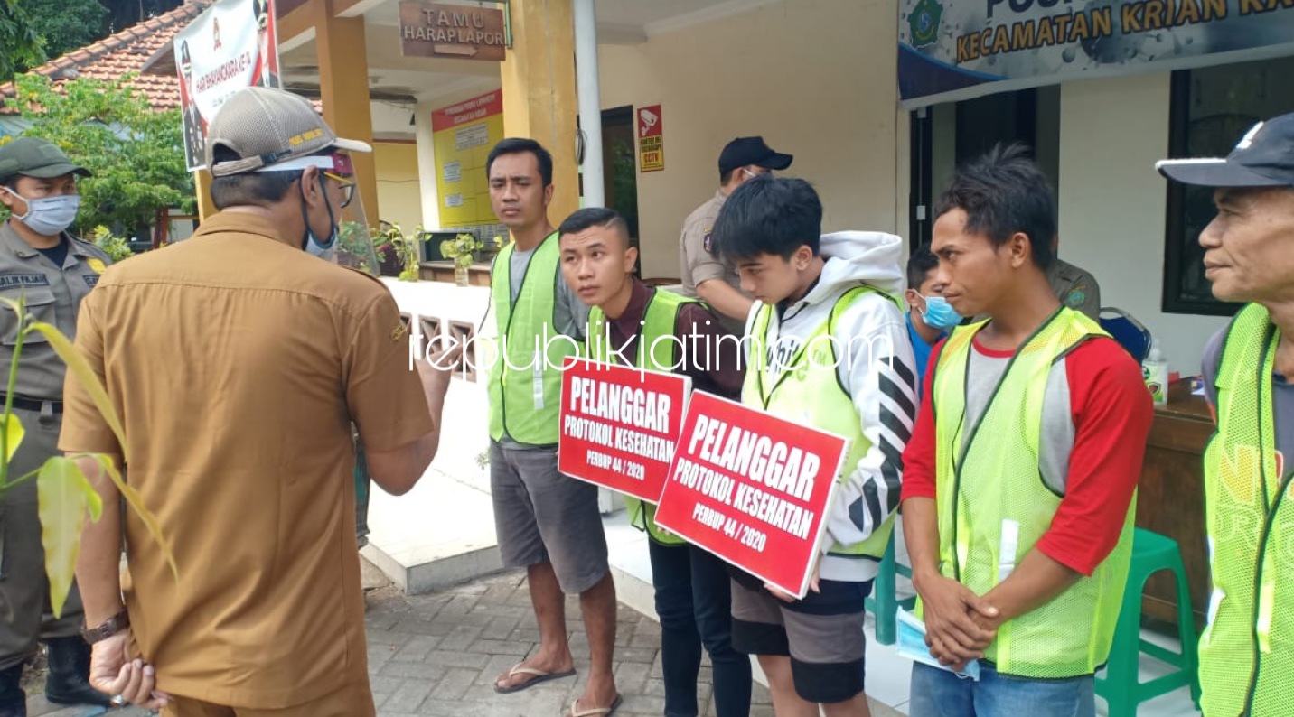 SANKSI SOSIAL - Sebanyak 26 pengendara yang terjaring operasi masker 15 diantaranya disanksi sosial bersih-bersih sisanya 11 orang disita KTP hingga 14 hari ke depan saat razia gabungan di depan kantor Kecamatan Krian, Senin (06/07/2020).