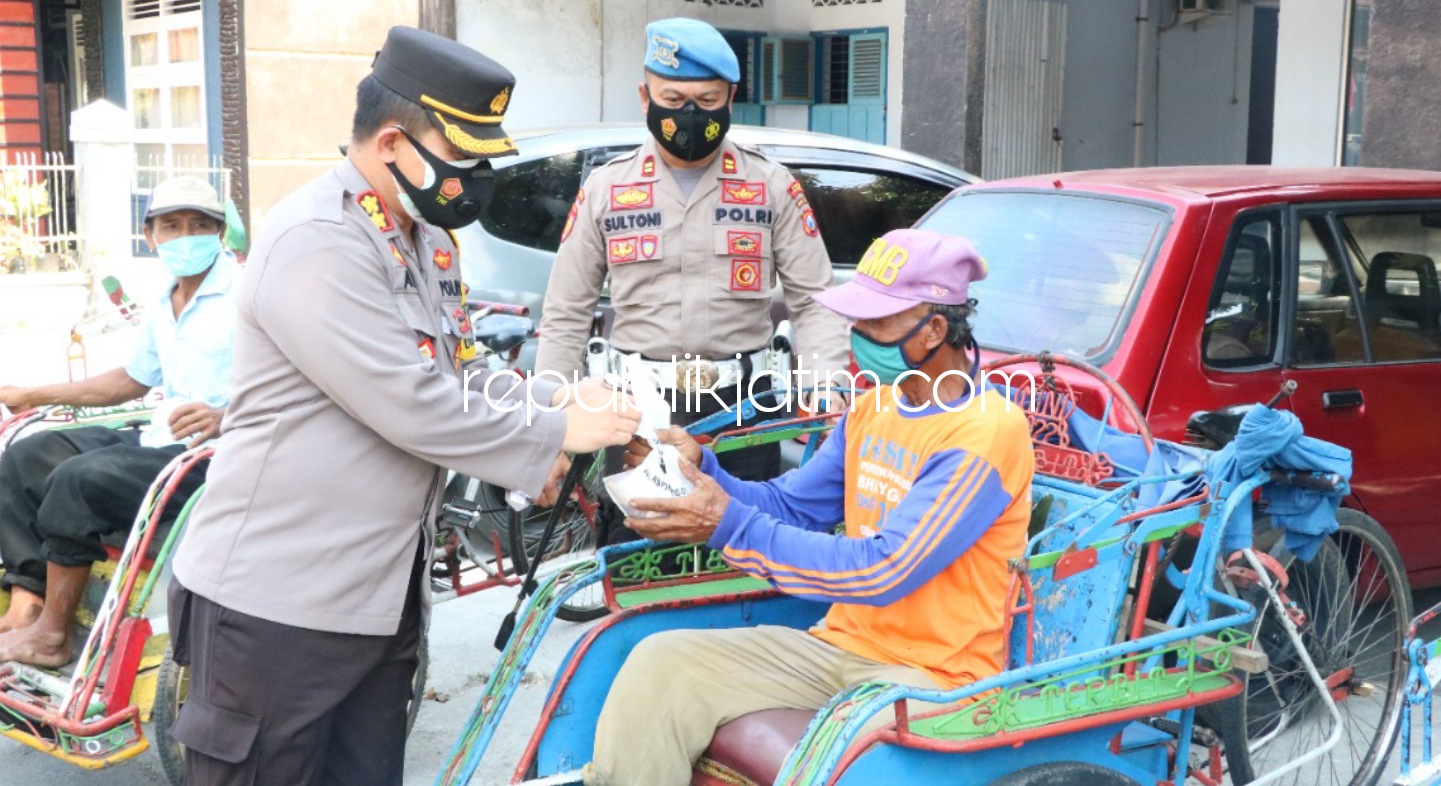 BAGIKAN - Kapolres Ponorogo AKBP Mochamad Nur Azis membagikan 3,5 kuintal lebih daging hewan kurban untuk para tukang becak dan juru parkir di Ponorogo, Selasa (20/07/2021). 