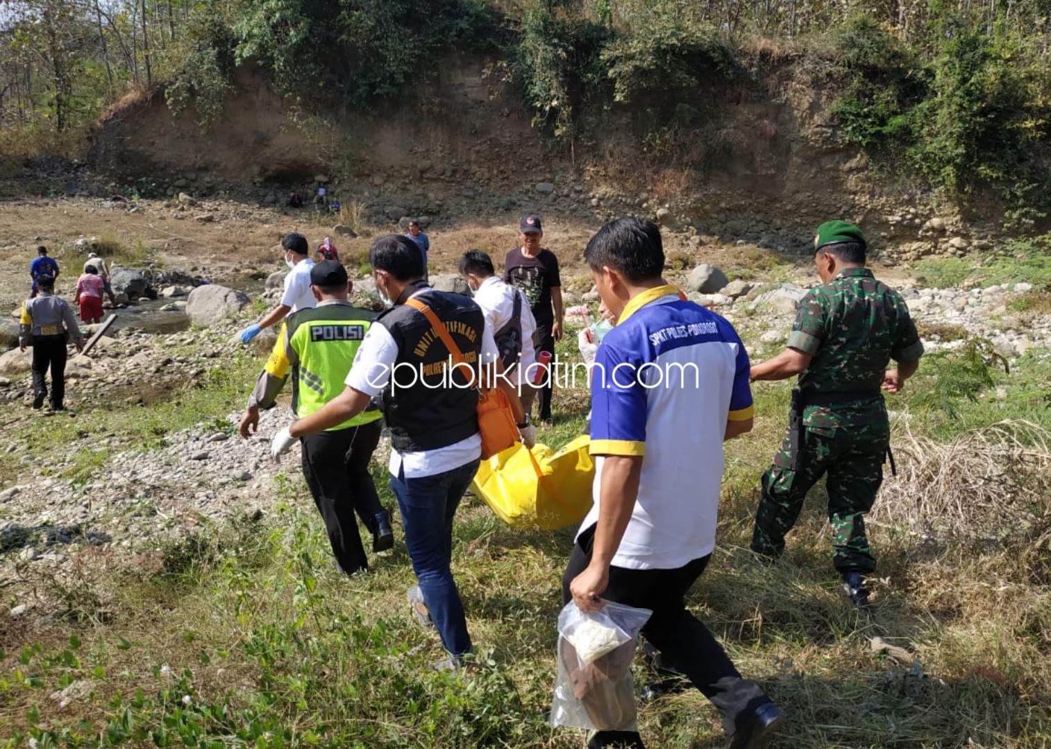 EVAKUASI - Petugas dan warga mengevakuasi mayat perempuan berusia sekitar 25 tahun yang ditemukan dibawa Jembatan Galok di Dusun Sampung Lor, Desa/Kecamatan Sampung, Ponorogo, Selasa (23/07/2019).