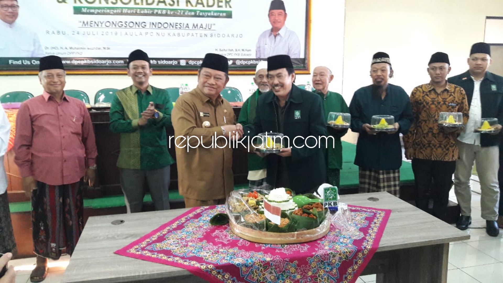 TUMPENG - Ketua DPC PKB Sidoarjo, Saiful Ilah menyerahkan tumpeng kepada Ketua Lembaga Pemenangan Pemilu (LPP) DPC PKB Sidoarjo, Nur Ahmad Syaifuddin dalam peringatan Harlah PKB ke 21, Rabu (24/07/2019) sore.