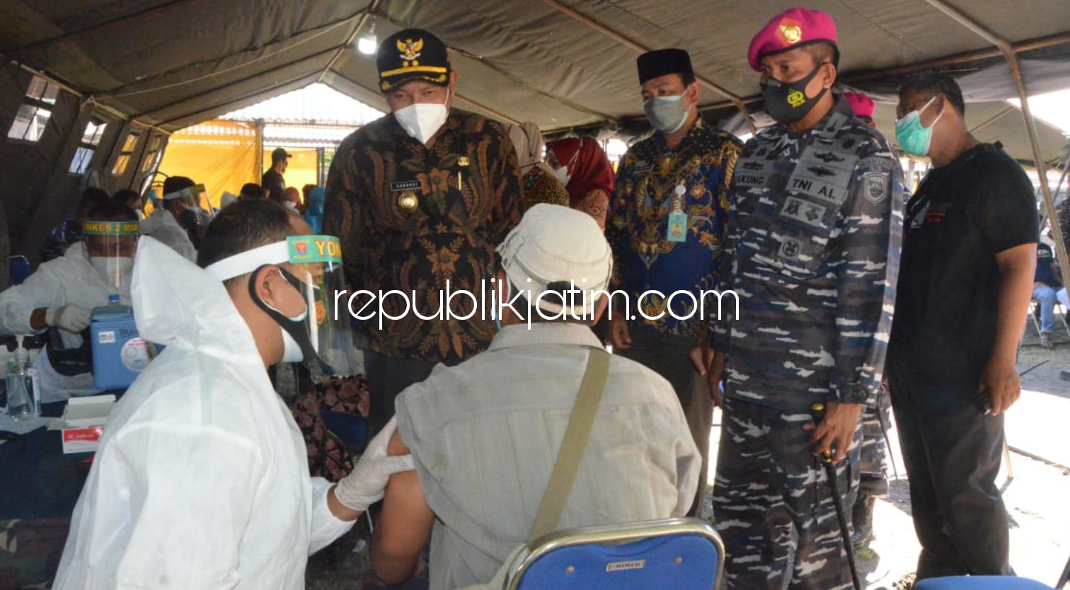 TINJAU - Wakil Bupati Sidoarjo, Subandi meninjau pelaksanaan vaksinasi 1.000 warga Desa Pepe, Kecamatan Sedati, di Lapangan Perum Candra Mas kerjasama dengan TNI AL (Pasmar), Sabtu (24/07/2021).