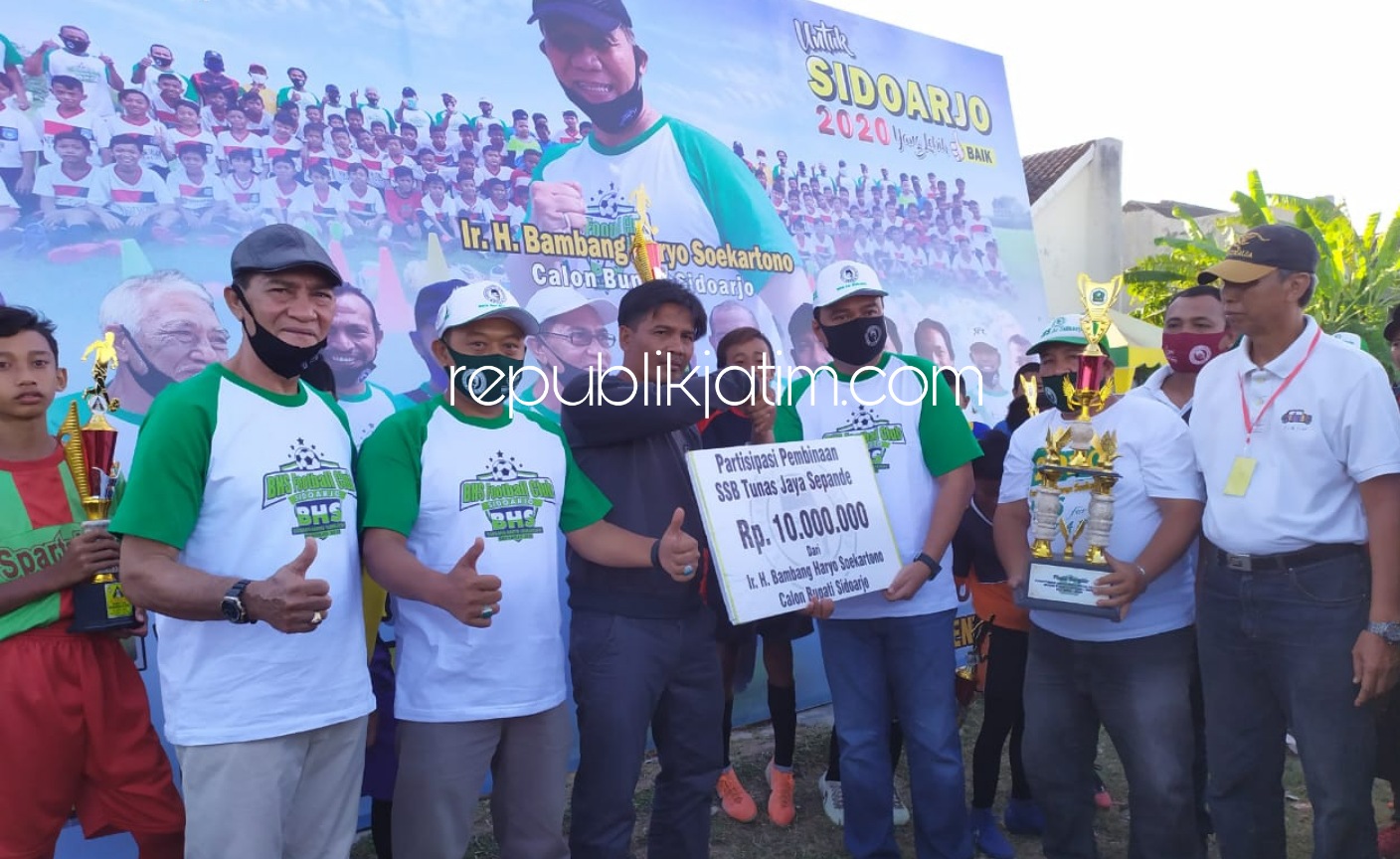 BANTUAN - Ketua Tim Pemenangan BHS, Wahyudin menyerahkan bantuan pembinaan senilai Rp 10 juta untuk SSB Tunas Jaya Sepande di Lapangan Sepande, Kecamatan Candi, Sidoarjo, Minggu (26/07/2020) sore.