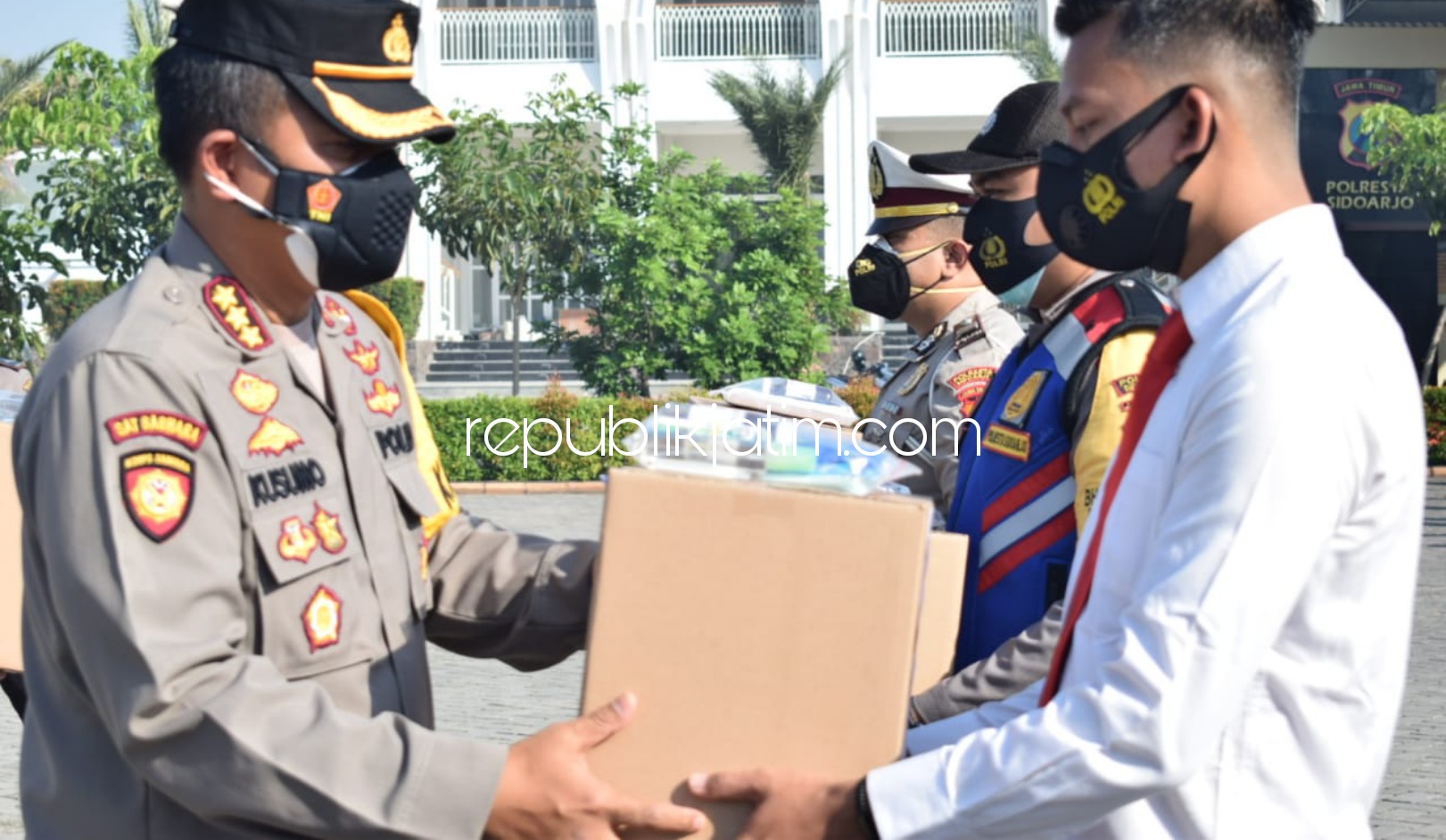 BEKALI - Kapolresta Sidoarjo Kombes Pol Kusumo Wahyu Bintoro menyalurkan bekal paket kesehatan bagi anggota Polri dan ASN di lingkungan Polresta Sidoarjo serta Polsek jajaran saat apel, Senin (26/07/2021).