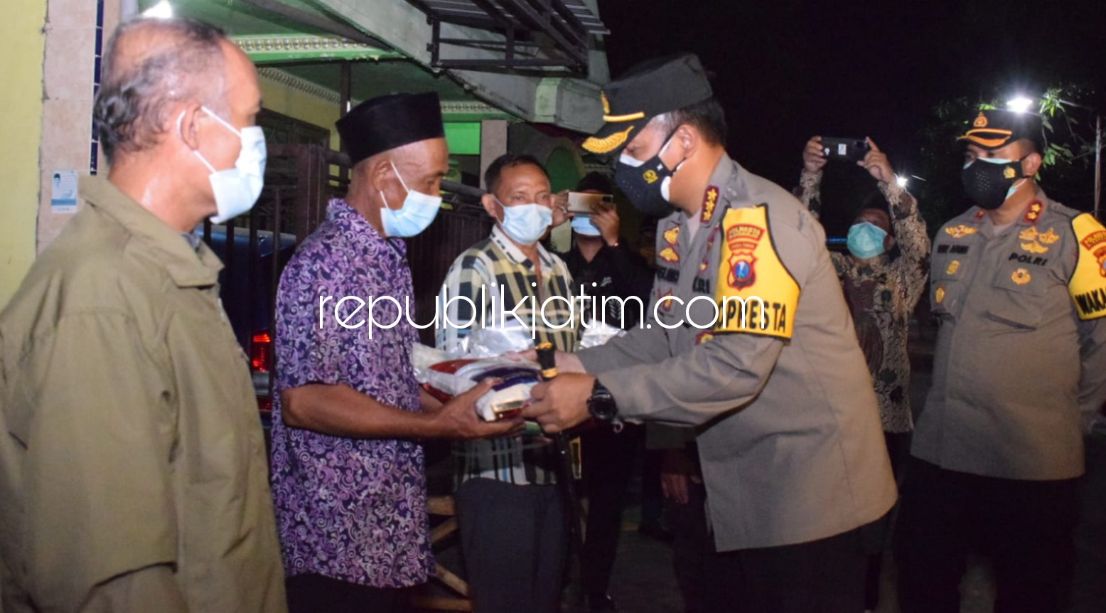 SALURKAN - Kapolresta Sidoarjo, Kombes Pol Kusumo Wahyu Bintoro beserta jajaran menyalurkan bantuan kepada para penggali makam dan warga nelayan di pesisir mendapatkan bantuan sosial paket sembako, Selasa (27/07/2021) malam.