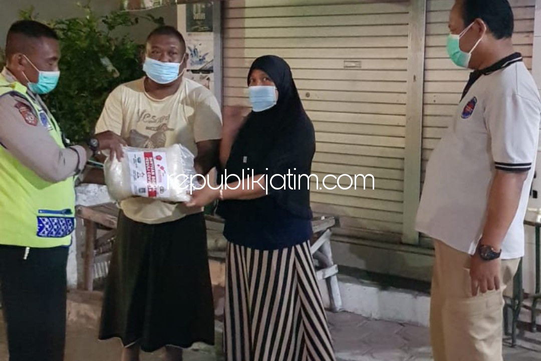 BAGIKAN - Sejumlah anggota Polsek Porong membagikan bendera dan sembako ke sejumlah pedagang dan tukang ojek, Sabtu (31/07/202) malam. 