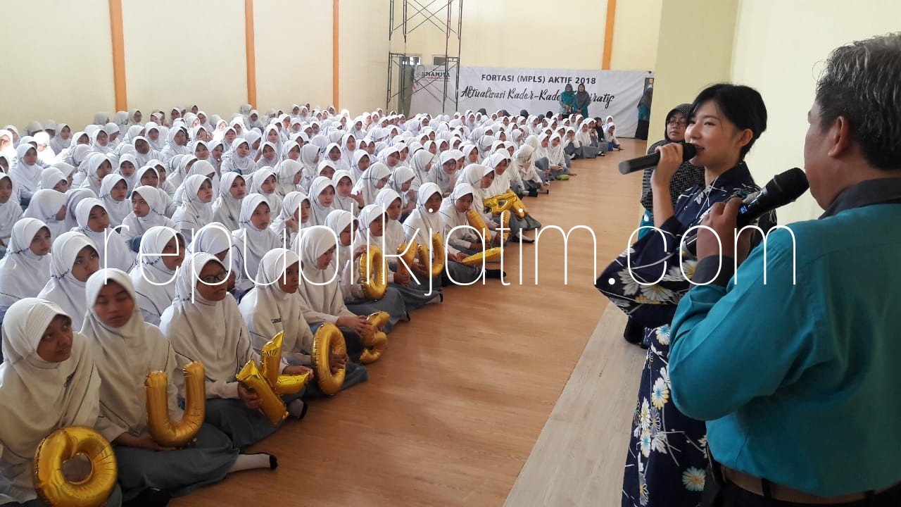 PERKENALAN - Guru tamu asal Jepang, Yurika Tanabe (22) memperkenalkan diri dihadapan ratusan siswa dan siswi Smamita, Sidoarjo bersama para dewan guru sebelum mengajar di sekolah ini selama 8 bulan ke depan, Senin (13/08/2018).
