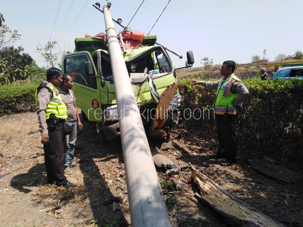 RINGSEK - Aiptu Tuwuh Wiyoto (kanan) dan Suliyono sopir truk melihat kondisi truk pasca kecelakaan menabrak tiang PJU di jalur Porong - Jabon, Desa Tambakkalisogo, Kecamatan Jabon, Sidoarjo, Kamis (16/08/2018).