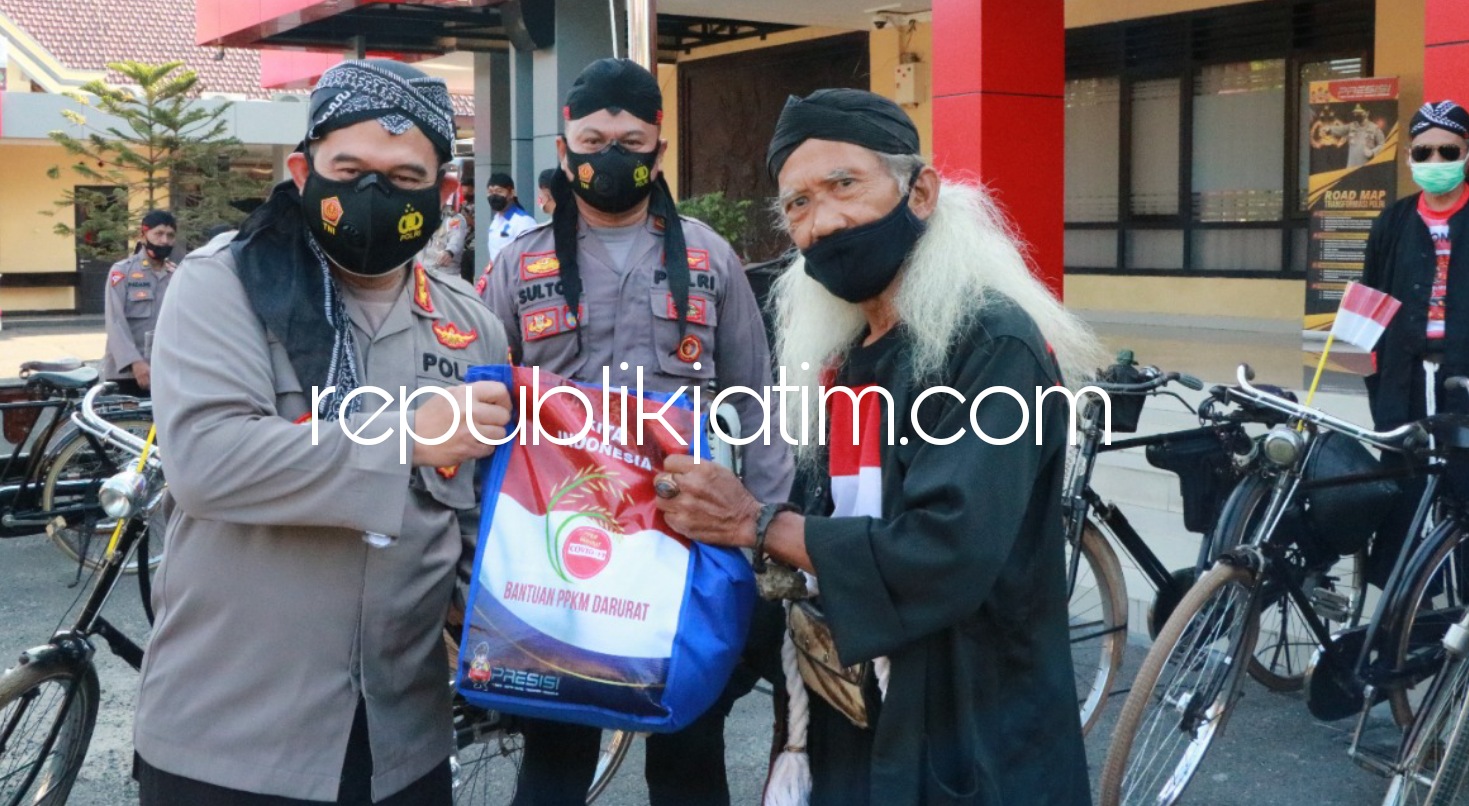 BERBAGI - Kapolres Ponorogo AKBP Mochamad Nur Azis bersama istri dan rombongan komunitas membagikan bingkisan untuk para pedagang sate dan anggota Komunitas Sepeda Kuno, Rabu (18/08/2021).