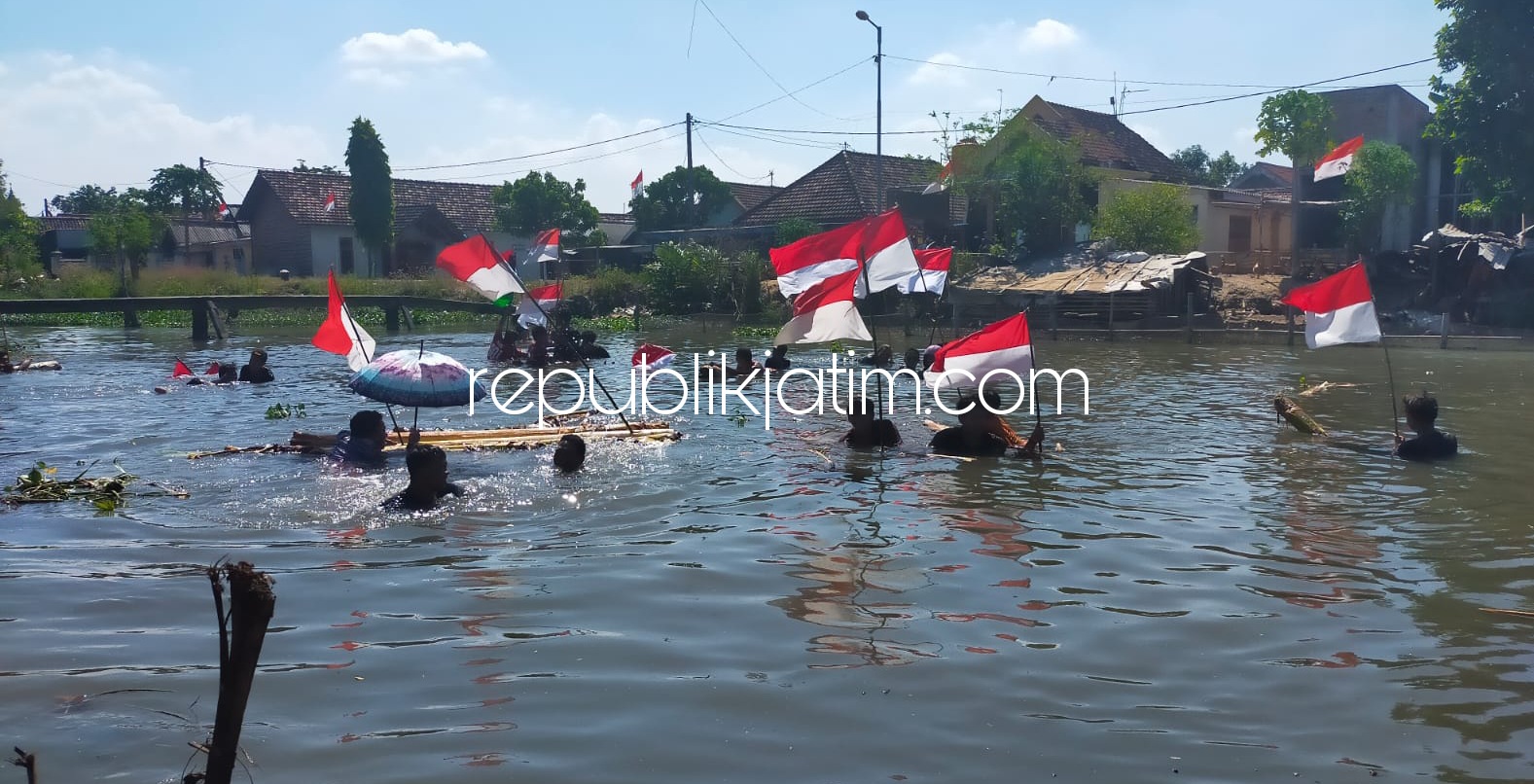 KEMERDEKAAN - Sebanyak 25 pemuda Desa Kraton, Kecamatan Krian, Sidoarjo mengibarkan bendera merah putih di Sungai Kraton sebagai salah satu cara memeriahkan Kemerdekaan RI ke 76, Selasa (17/08/2021).
