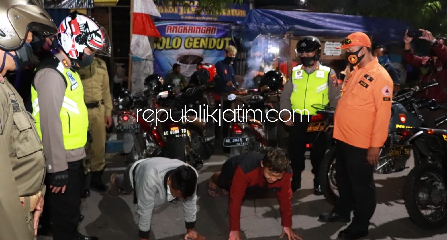 PATROLI - Petugas gabungan berpatroli memberikan sanksi push up kepada warga yang tidak disiplin menerapkan protokol kesehatan salah satunya tidak menggunakan masker, Selasa (18/08/2020) malam.