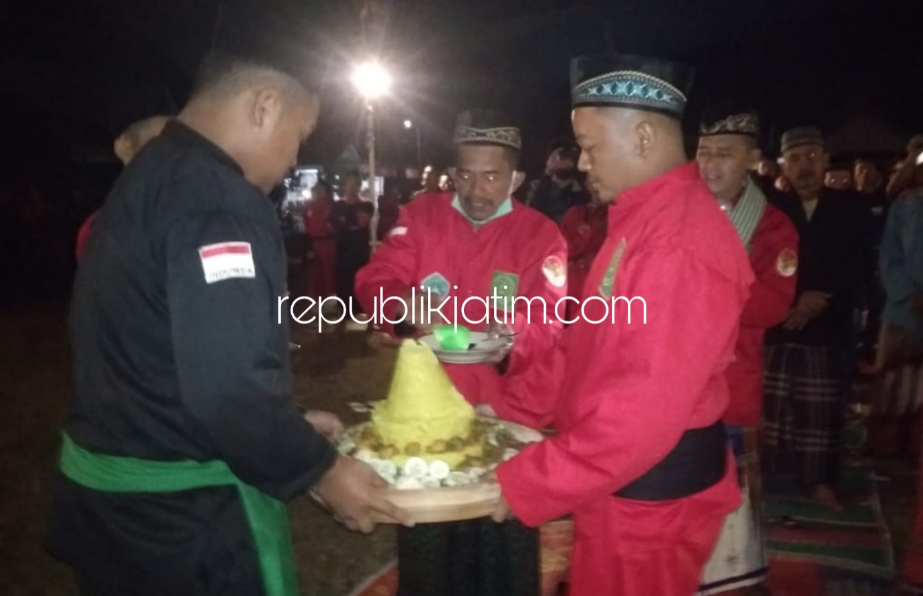 POTONG TUMPENG - Pemotongan tumpeng di tengah pagar seribu obor dilakukan Ketua Ranting tanda diakhirinya acara tahlil seribu obor di lapangan Desa Munggu, Kematan Bungkal, Ponorogo, Rabu (19/08/2020) malam.