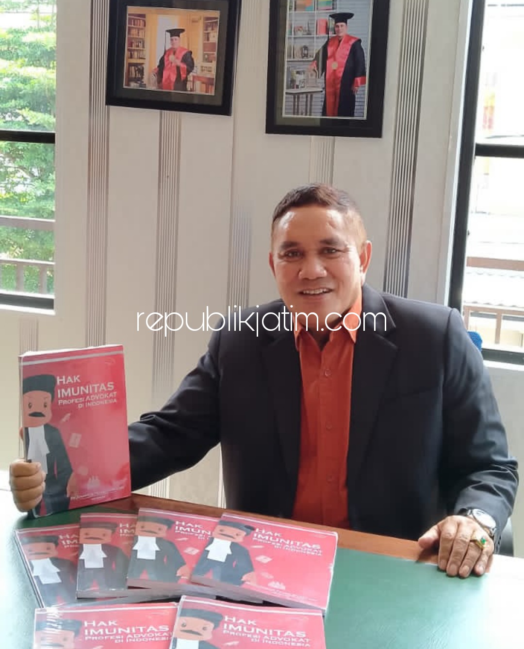 TUNJUKKAN - Pengacara kondang, Dr Danggur Feliks SH MH MM saat menunjukkan hasil karya sebuah buku tulisannya sebagai bahan referensi para pengacara dalam menjalankan profesinya, Minggu (22/08/2021). 