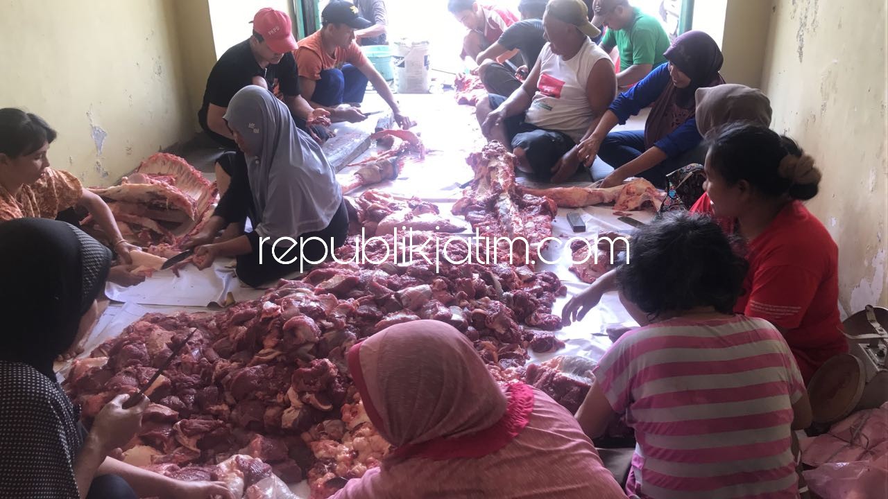 KURBAN - Para tetangga Sekretaris Komisi C DPRD Sidoarjo, M Nizar sibuk membagikan daging kurban dari penyembelihan sapi untuk sekitar 400 warga Dusun Parengan, Desa Kraton, Kecamatan Krian, Sidoarjo, Rabu (22/08/2018).