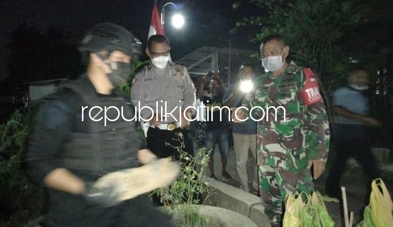 EVAKUASI - Tim Gegana Polda Jatim disaksikan petugas Polsek dan Koramil beserta warga sekitar mengevakuasi mortir (amunisi) pesawat yang terpendam separuh di pinggir sungai Desa Suwaluh, Kecamatan Balongbendo, Sidoarjo, Minggu (22/08/2021) malam.