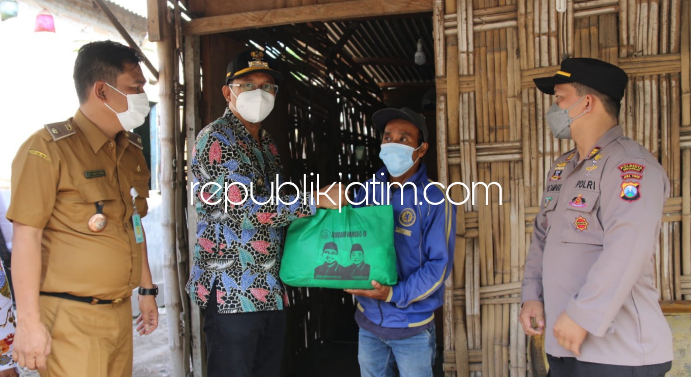 PRIHATIN - Bupati Sidoarjo, Ahmad Muhdlor Ali (Gus Muhdlor) menyerahkan bansos sembako kepada Satu'in (44) salah satu warga Desa Jatikalang, Kecamatan Prambon, Sidoarjo yang tinggal di rumah bambu bersama istri dan seorang anaknya, Senin (23/08/2021).