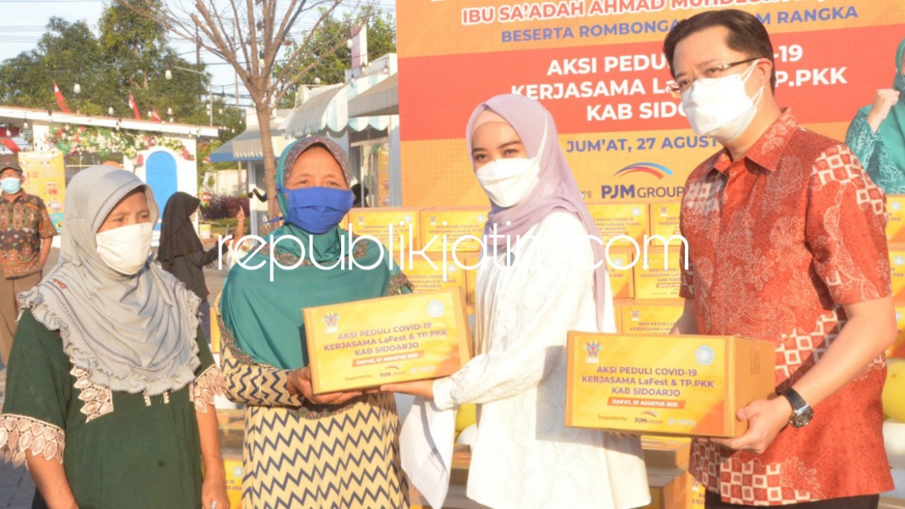 SERAHKAN - Istri Bupati Sidoarjo, Ny Sa'adah Ahmad Muhdlor Ali menyerahkan bansos PT LaFest untuk warga sekitar di Desa Jemundo, Kecamatan Taman, Sidoarjo, Jumat (27/08/2021).