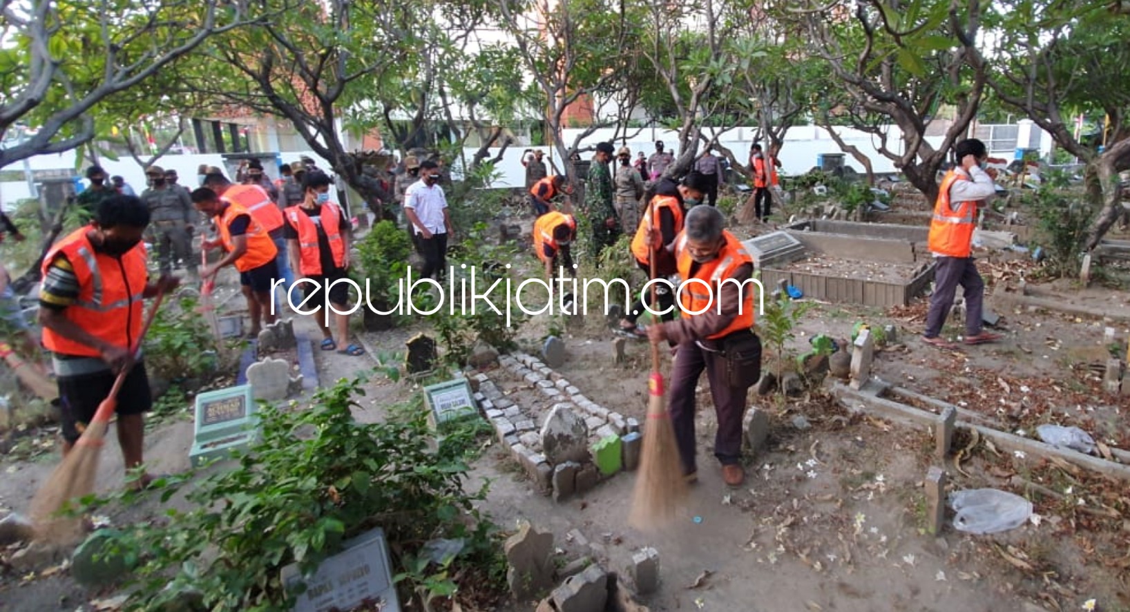 BERSIHKAN MAKAN - Puluhan pelanggar protokol kesehatan tak menggunakan masker disanksi bersihkan makam Waru menggunakan rompi pelanggar, Senin (31/08/2020). 