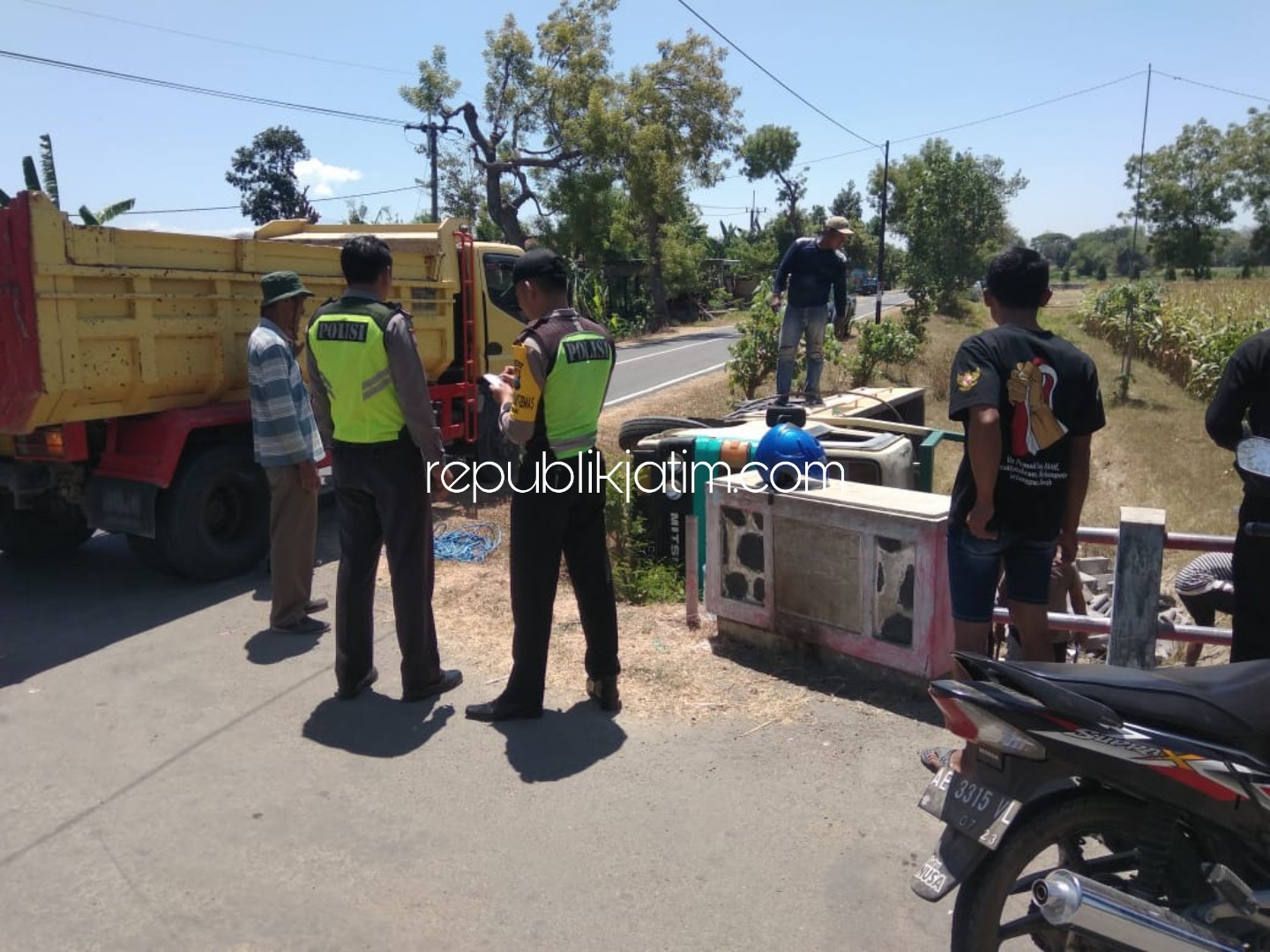 TERGULING - Sejumlah polisi dan warga berusaha mengevakuasi truk material yang terguling di JL Raya Ngumpul - Sumoroto, Dusun Ngasem, Desa Bringinan, Kecamatan Jambon Ponorogo, Senin (02/09/2019).