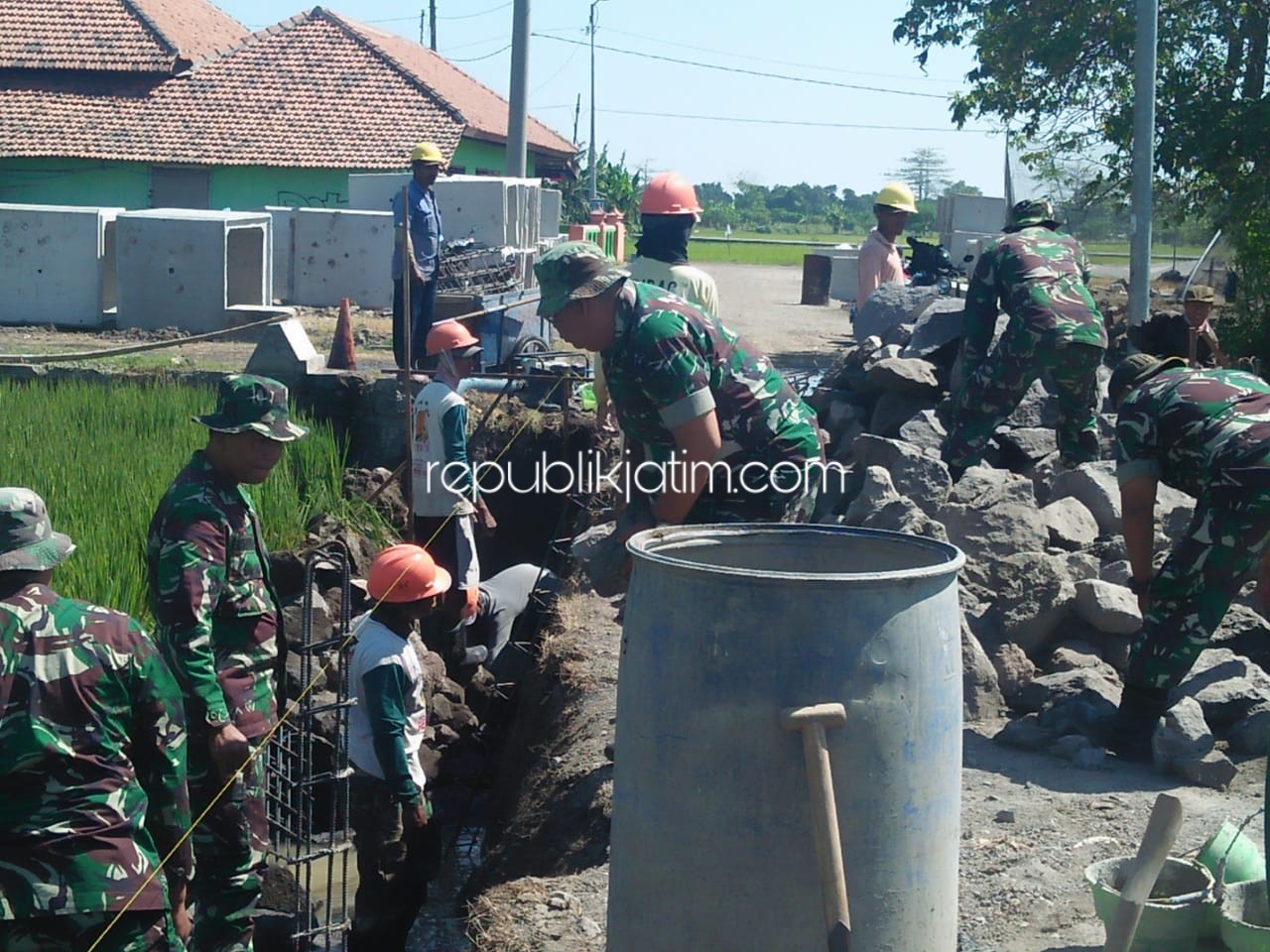 KERJAKAN - Sejumlah anggota Kodim 0816 Sidoarjo membangun jalan dan jembatan sebagai target dalam TMMD di Desa Kupang, Kecamatan Jabon, Sidoarjo, Minggu (22/09/2019).