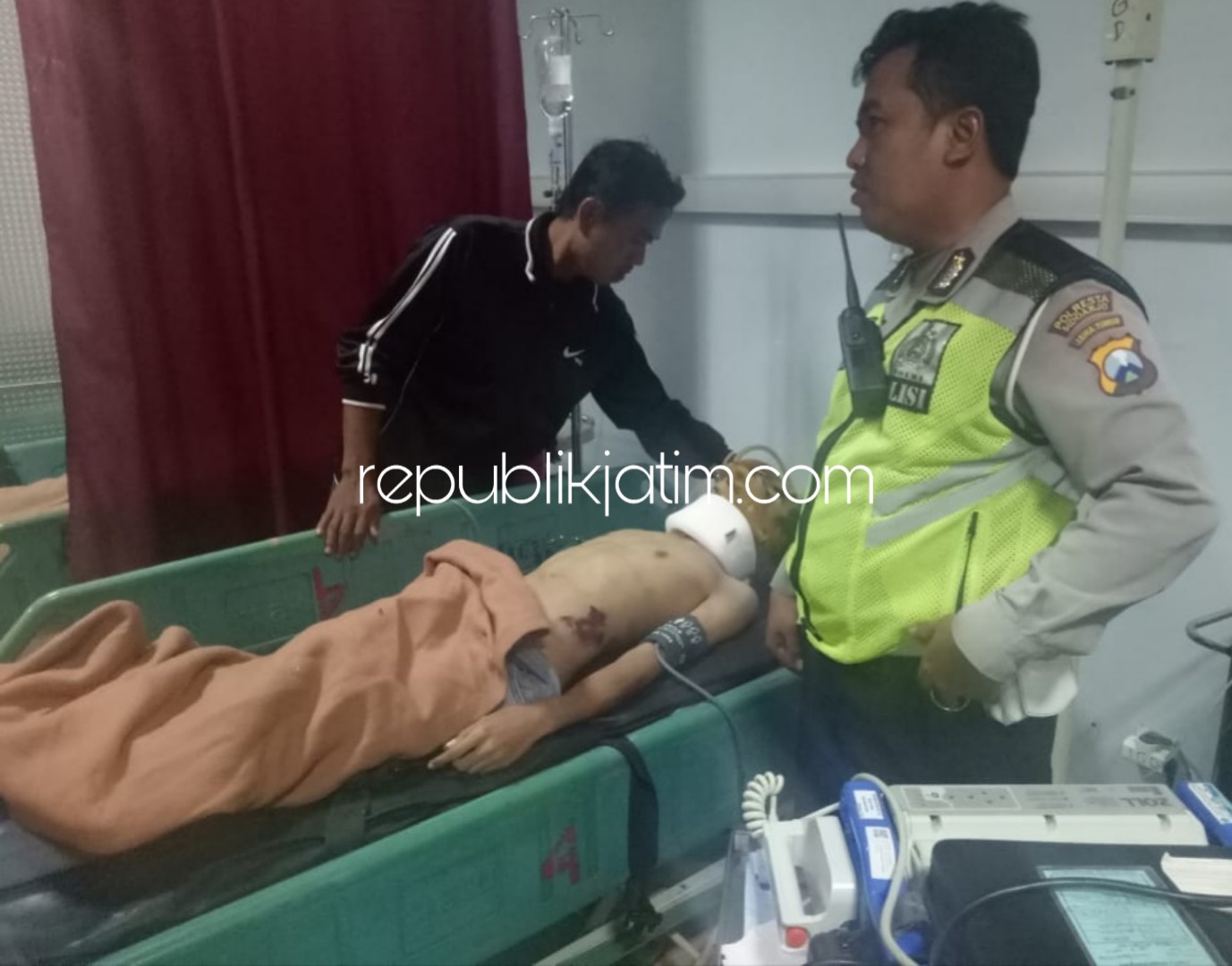 DIRAWAT - Petugas Polsek Porong, Aiptu Murtafiq melihat kondisi korban Ahmad Gozali yang menjalani perawatan tim medis RSUD Sidoarjo, Minggu (23/09/2018).