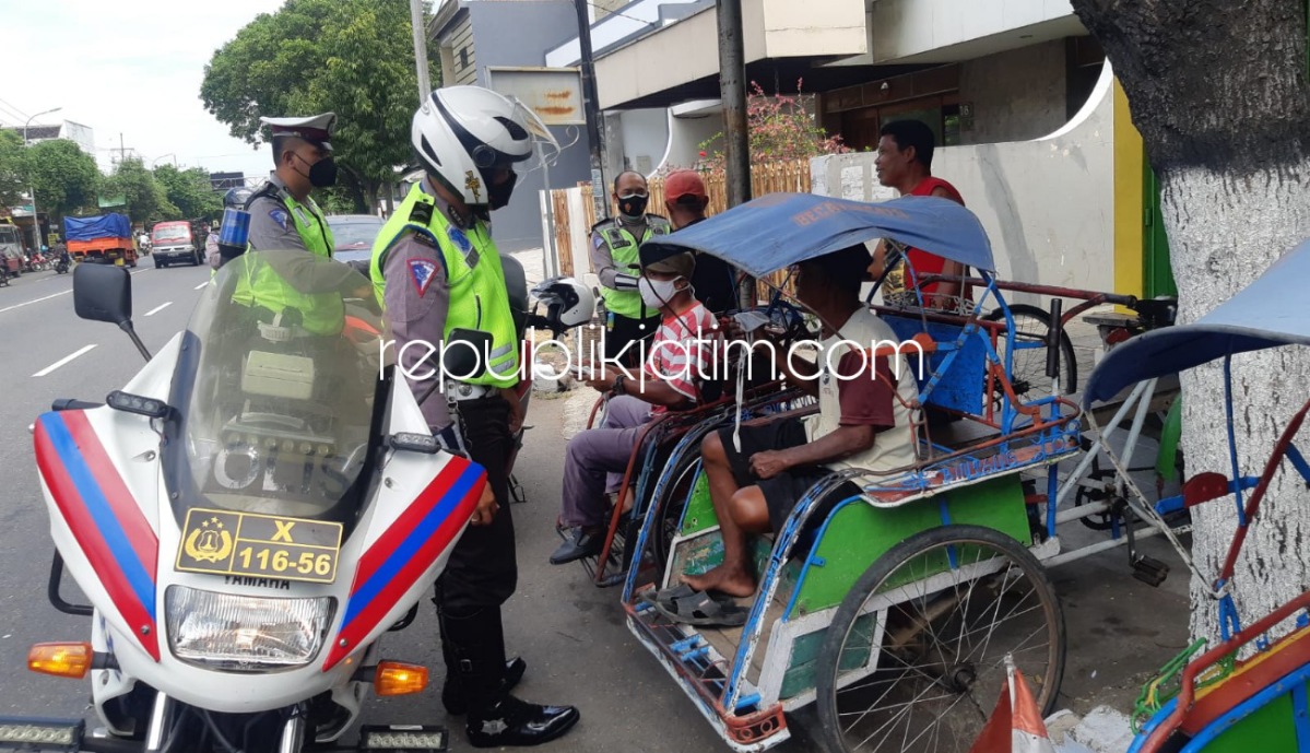 BAGI MASKER - Sejumlah petugas Satuan Lantas Polres Ponorogo membagikan masker saat Operasi Patuh Semeru, Minggu (26/09/2021). 
