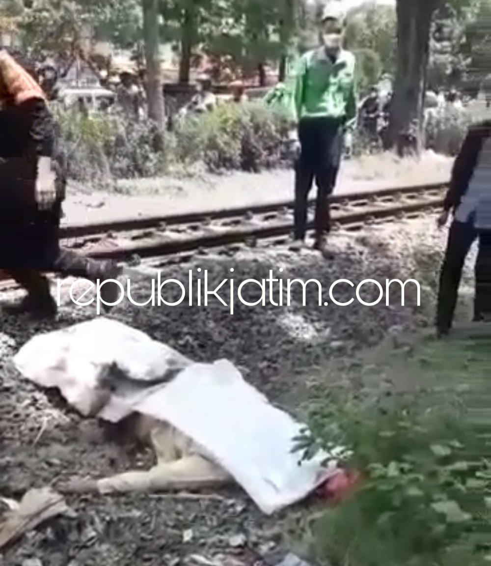 EVAKUASI - Sejumlah petugas mengevakuasi korban kecelakaan tertabrak KA, Nanik Suciani (60) guru asal Perum Tropodo Asri, Desa Tropodo Kecamatan Waru yang tertabrak KA di perlintasan Desa/Kecamatan Waru, Sidoarjo, Senin (27/09/2021).
