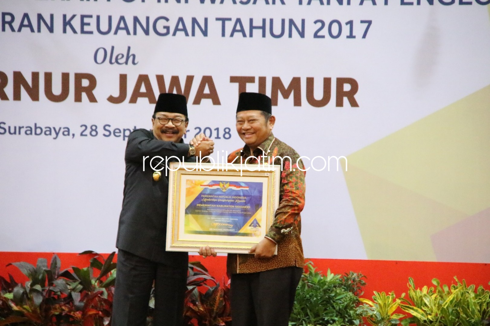 WTP - Gubernur Jatim, Soekarwo menyerahkan penghargaan ke Bupati Sidoarjo, Saiful Ilah atas prestasi menyajikan laporan keuangan dengan predikat Wajar Tanpa Pengecualian (WTP) di Ruang Hayam Wuruk Kantor Gubernur Jawa Timur, Surabaya, Jumat (28/09/2018).