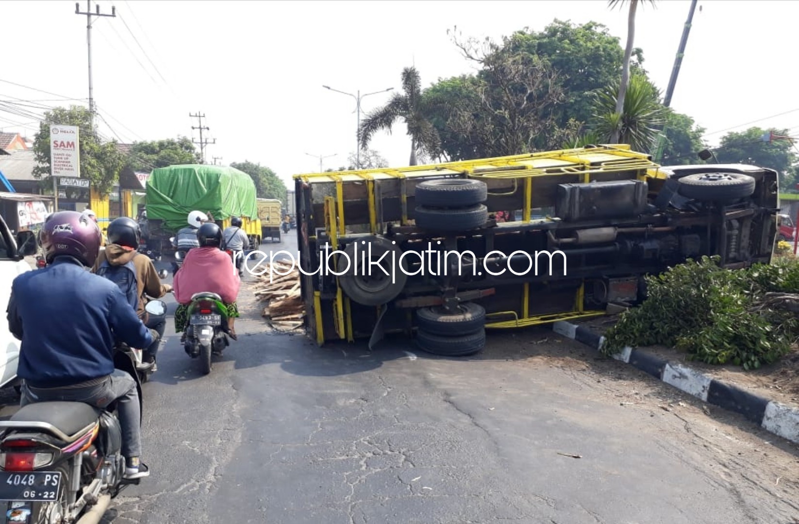 TERGULING - Truk bermuatan kulit kayu terguling di JL Raya Tanggulangin hingga muatan tumpah menutup jalan memicu kemacetan jalur utama itu, Senin (01/10/2018). 