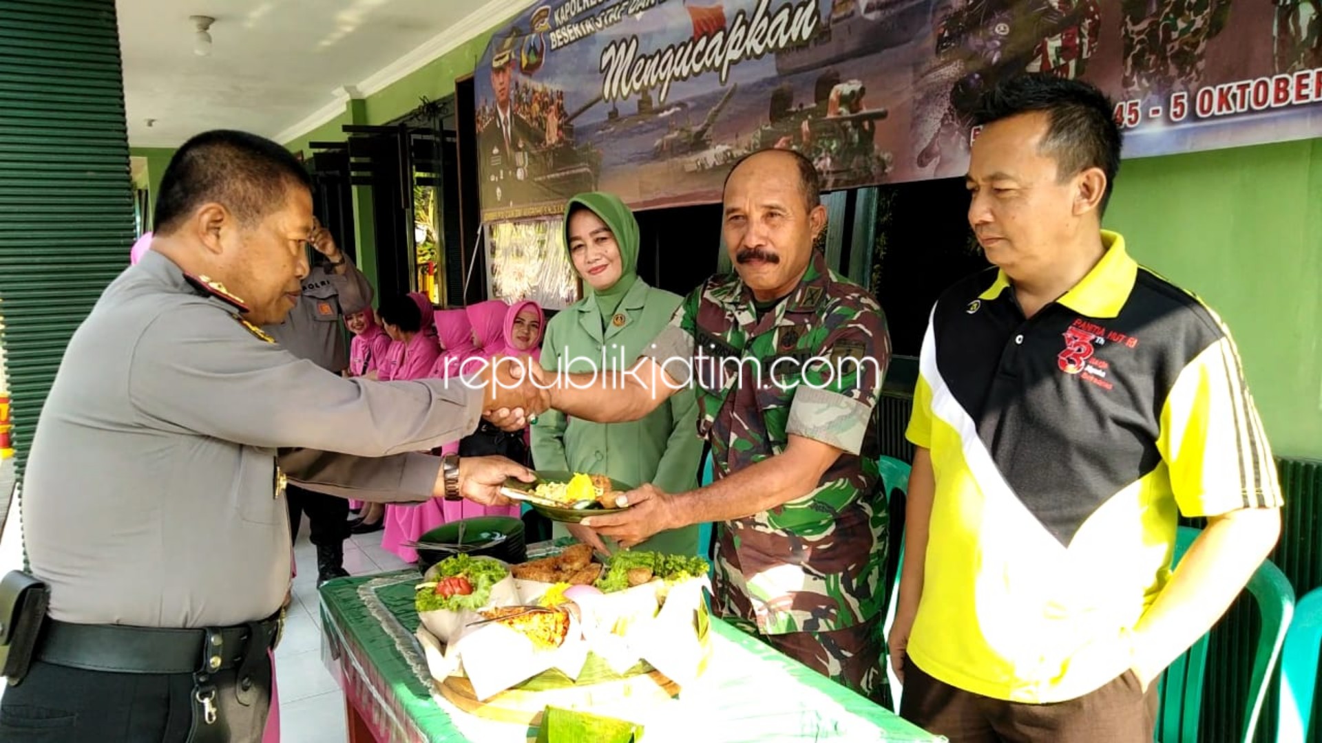 TUMPENG - Danramil 0816/04 Porong, Kapten Inf Adi Sutrisno (kanan) dan Kapolsek Porong Kompol Wagiyo (kiri) saat memberikan potongan tumpeng, Jumat (04/10/2019).
