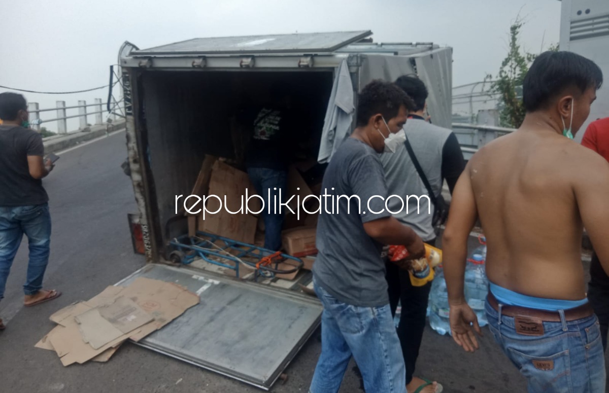 TERGULING - Truk Bok bernopol L 926 BY yang dikemudikan Kresna Yusuf Handoko (28) warga Simo Rukun, Sukomanunggal, Kota Surabaya terguling di Flyover Desa Masanganwetan, Kecamatan Sukodono, Sidoarjo, Senin (04/10/2021).