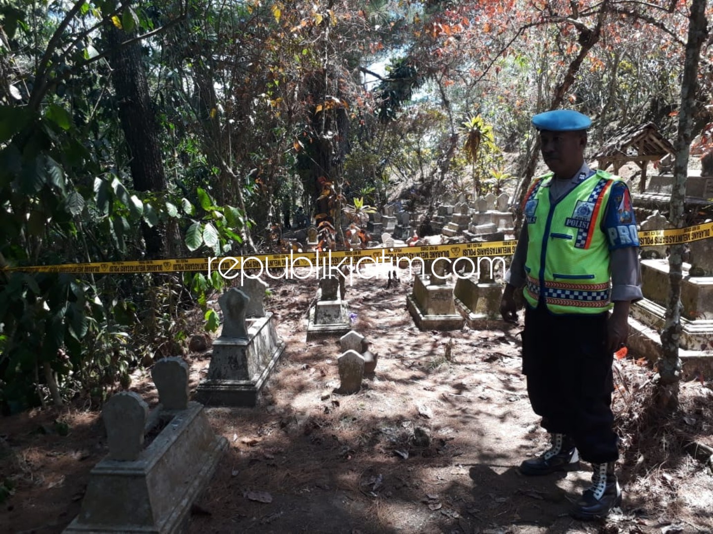 DIPOLICE LINE - Anggota Polres Ponorogo memberi police line dan menjaga makam bayi hasil hubungan gelap bapak dan anak tirinya di Dusun Toyomarto, Desa Pupus, Kecamatan Ngebel, Ponorogo, Senin (09/10/2018).