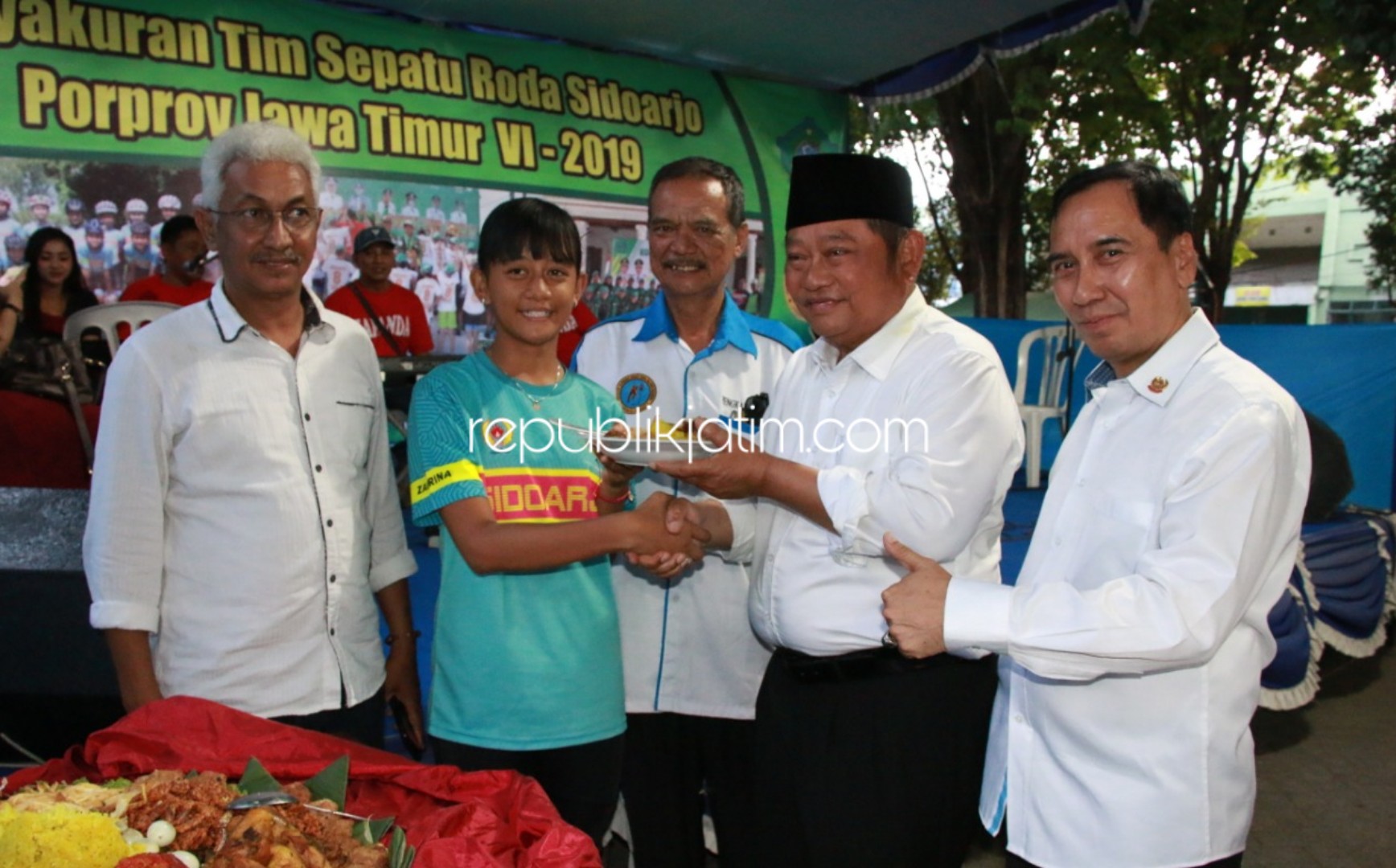 TUMPENGAN - Bupati Sidoarjo, Saiful Ilah memberikan potongan tumpeng kepada salah satu atlet Sepatu Roda di lapangan Sepatu Roda GOR Sidoarjo, Sabtu (12/10/2019).