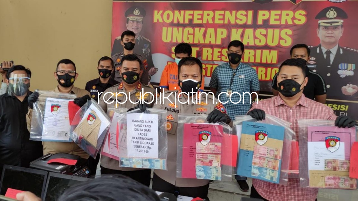 DIGELANDANG - Kades Klantingsari, Kecamatan Tarik, Sidoarjo Wawan Setyo Budi Utomo (45) digelandang dan ditetapkan tersangka tunggal kasus dugaan pungli PTSL dengan barang bukti uang senilai Rp 69 juta saat rilis di Polresta Sidoarjo, Kamis (14/10/2021).